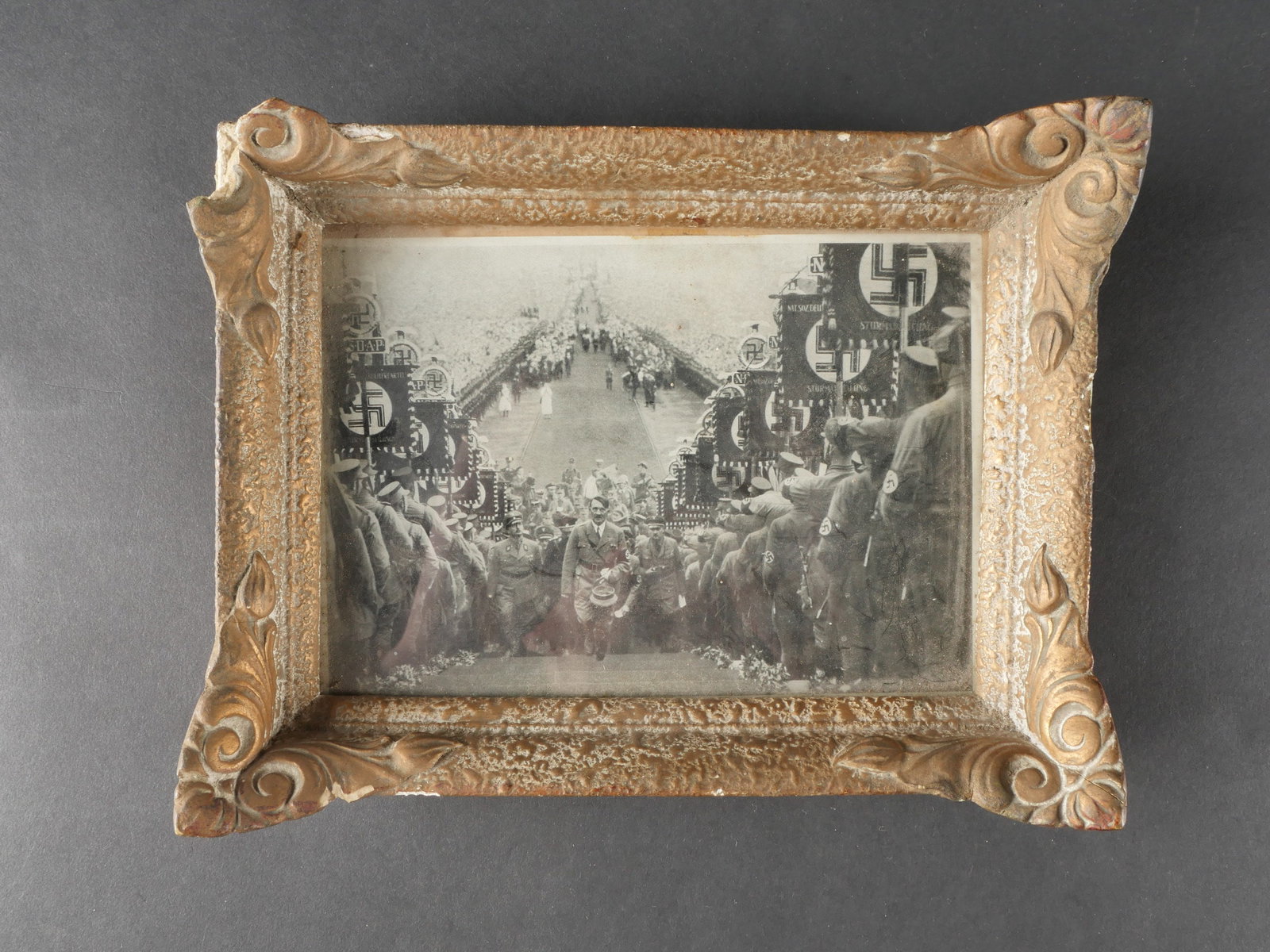 Tableau allemand. German picture: Tableau allemand compose d’une image de presse decoupee dans un magazine representant le chancelier allemand montant a la tribune du Reichsparteitag de Nurnberg entoure de membres de la SA. L’imag