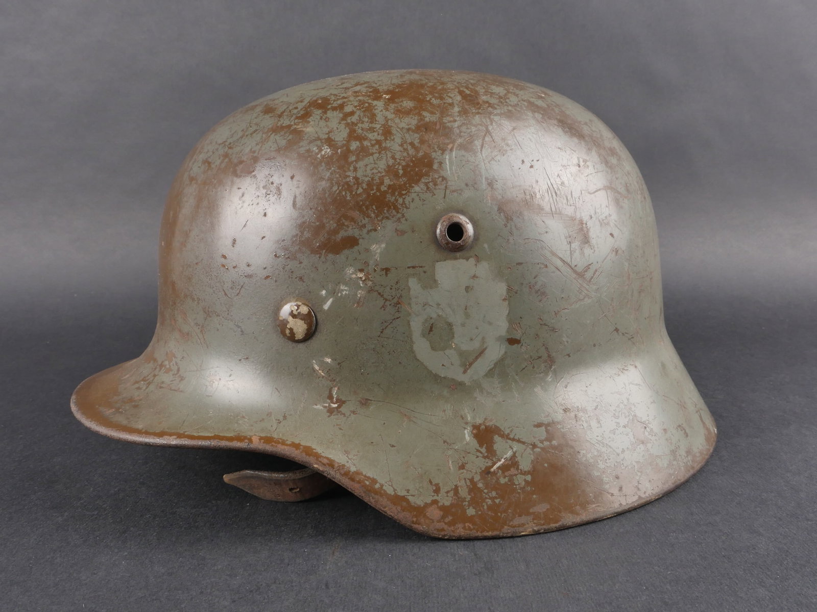 Casque Polizei.: Casque Polizei. Coque de casque M-35, numero de lot 0777, fabrication Q 64. Coiffe en cuir complete. Le cordon de serrage est manquant. Jugulaire en cuir complete. Peinture a 50%. Insigne national a 5