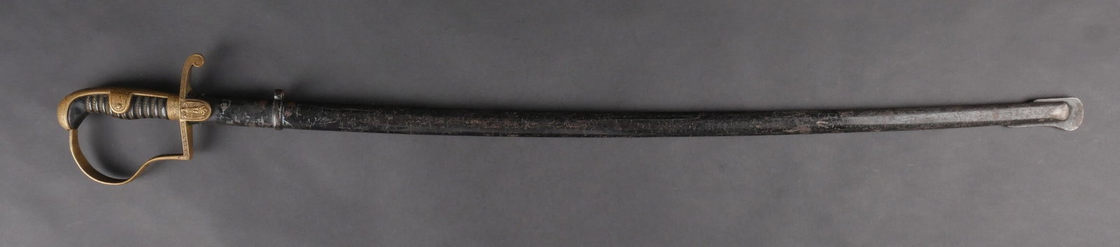 Epee d officier allemand. German officer’s sword: epee d’officier allemand. Garde, poignee et pommeau a decors floraux. Poignee en bois noir avec filigrane dore complet. Garde decoree d’un ecu portant un aigle aux ailes repliees. Quelques fissure