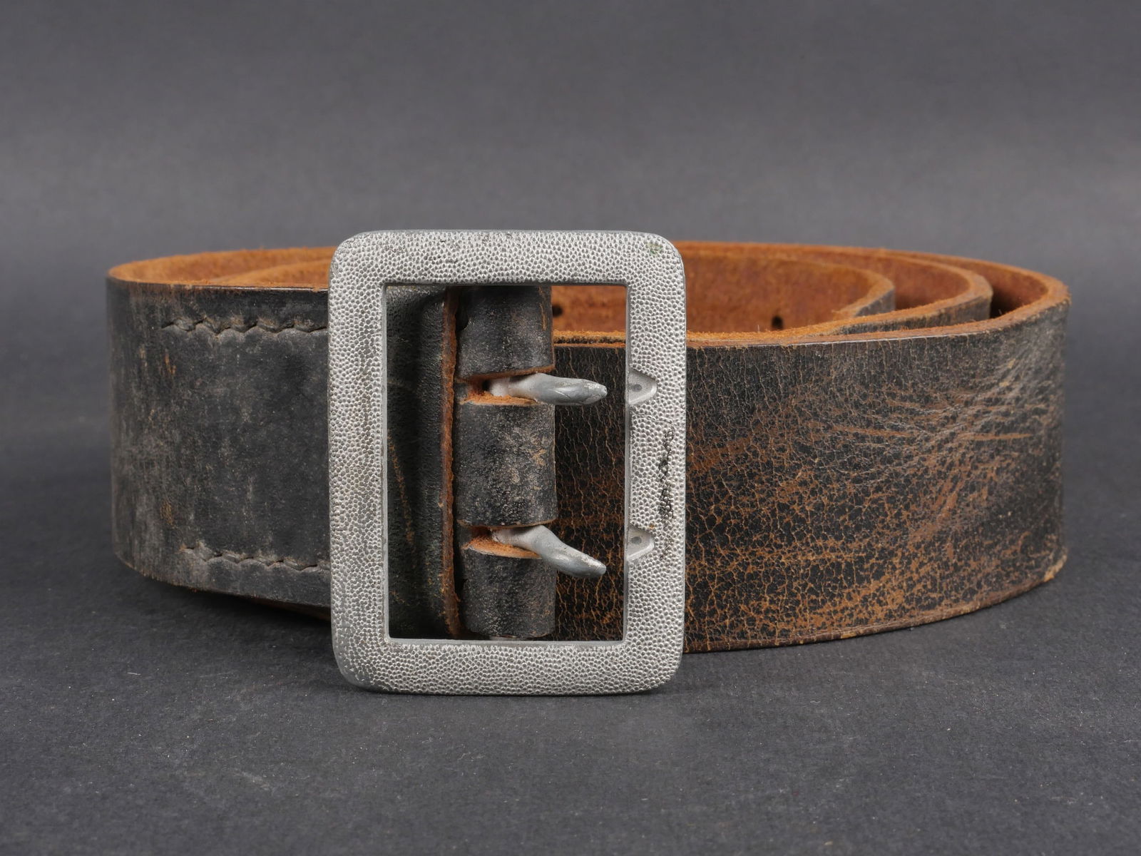 Ceinturon officier de la Heer. German officer belt.: Ceinturon de la Heer. Modele d’officier en cuir noir avec boucle en metal grenele de couleur argent. Deux ardillons complets. Aucun marquage visible. Presente une usure et une patine caracteristique