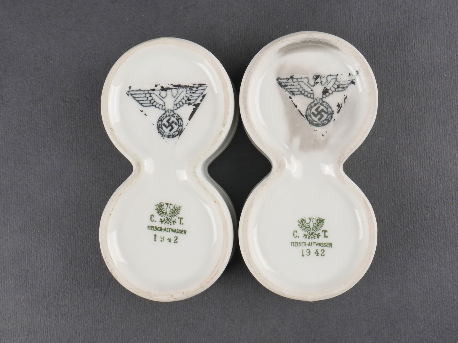 Sels et poivre de la Heer. Heer salt and pepper shakers: Saliere et poivriere de la Heer. Ensemble en ceramique blanche decore de deux aigles de la Heer. Marquages CT Tielsch Altwasser 1942. Patine d’usage visible. etat II+. Heer salt and pepper set. Whit