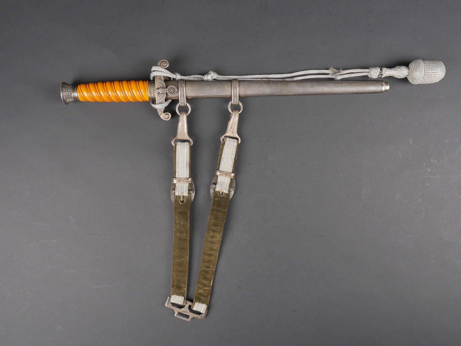 Dague officier Heer. Heer officier dagger.: Dague d officier de la Heer. Garniture en metal. Poignee en celluloid jaune. Belle lame presentant quelques taches. Fabrication Eickhorn Solingen. Fourreau complet mais partiellement oxyde. Dragonnes