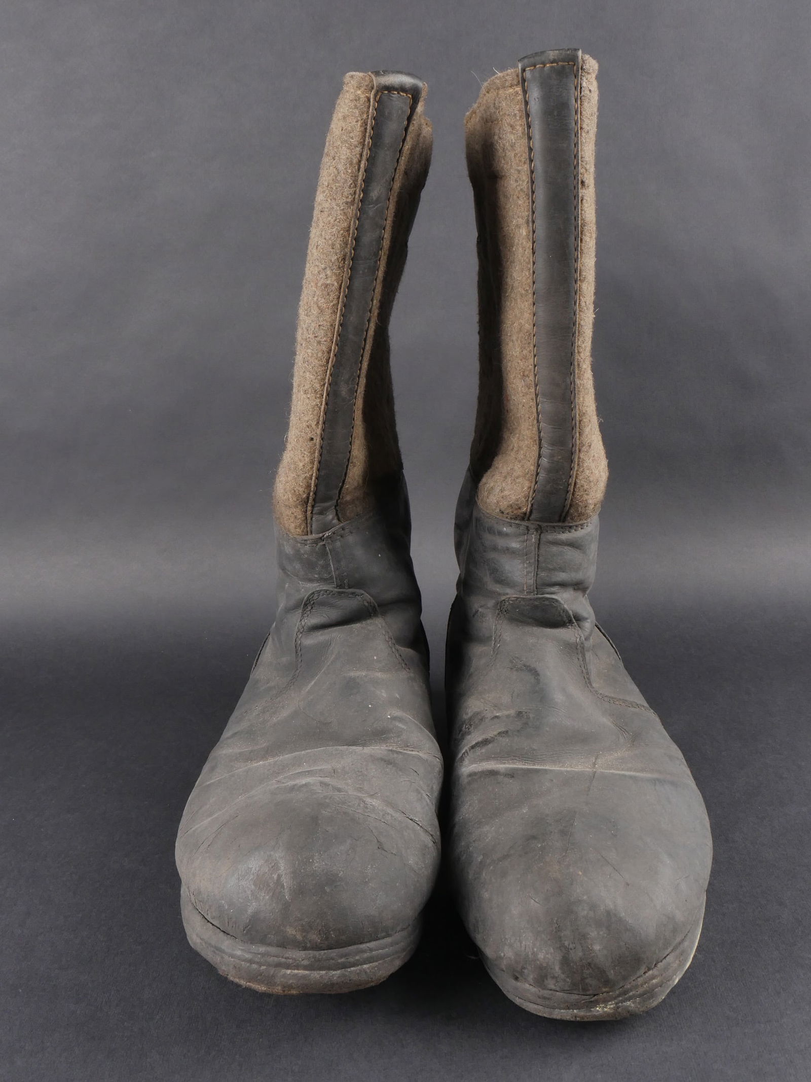 Bottes en feutre. German boots.: Bottes hivernales en feutre avec parties en cuir noir et feutre Feldgrau. Paire homogene avec pattes de serrage arrieres completes. Semelles fortement usees. Fabrication 31 7 42 5588. Usure notable, p
