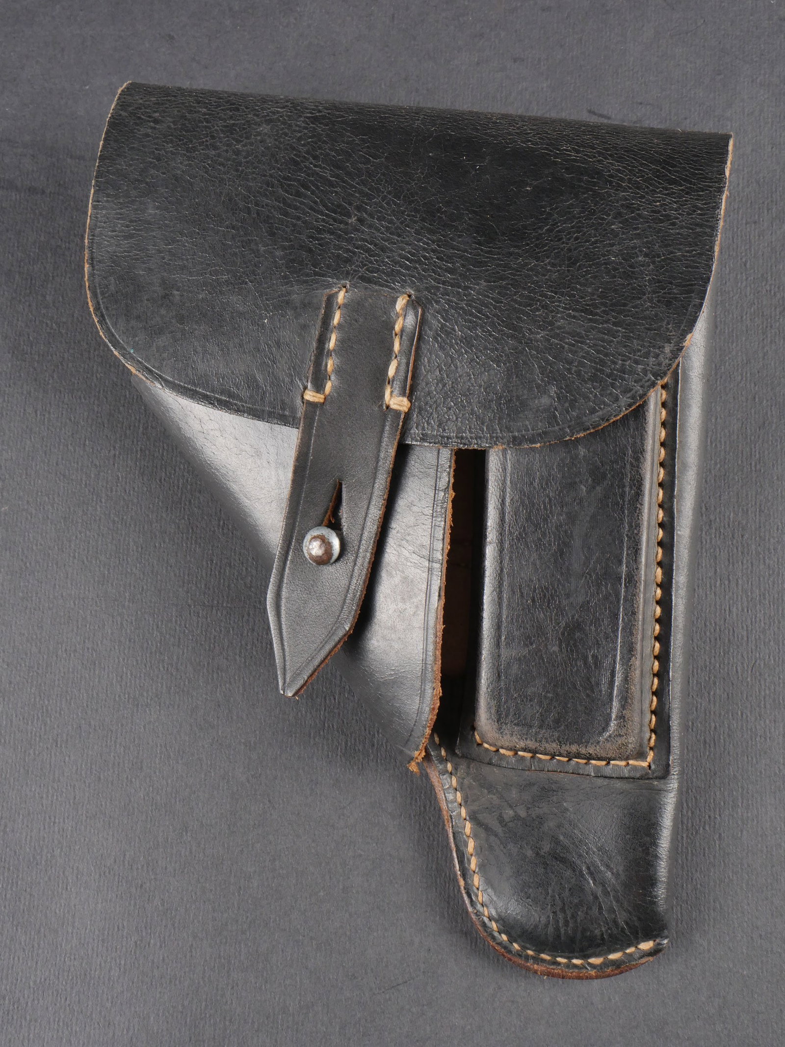 Holster de pistolet allemand. German pistol holster.: Holster de pistolet allemand en cuir noir lisse. Sangle de fermeture et passant arriere presents. Piece en cuir portant le numero 507. Marquages caviardes sous le rabat. Aigle Waa 068 visible. Legere 
