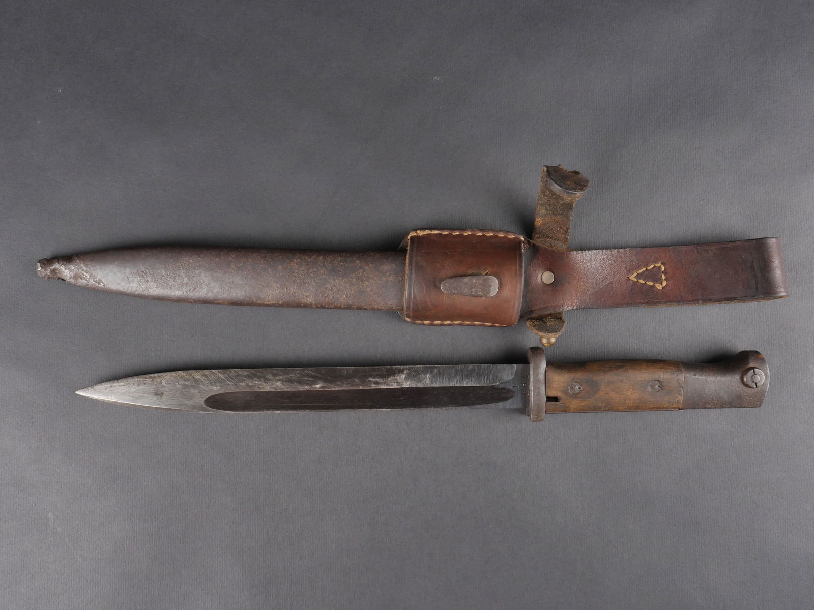 Baionnette de Mauser 98K. Mauser 98K bayonet.: Baionnette de Mauser 98K. elements metalliques partiellement oxydes. Plaquettes en bois fixees par deux rivets. Bouton-poussoir fonctionnel. Belle lame conservee a 60 % dans sa teinte d’origine. Fab