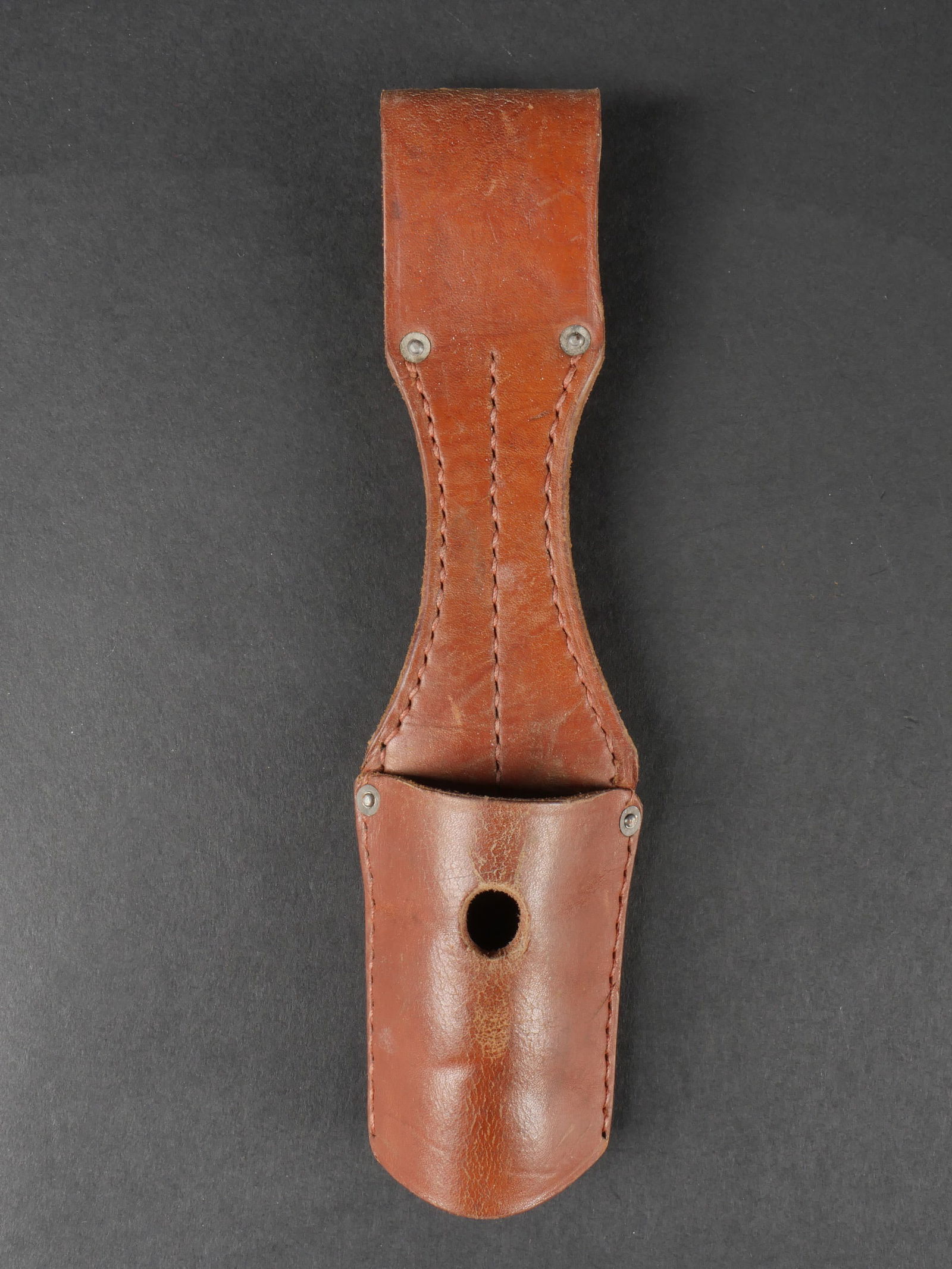 Gousset de baionnette 98K. 98K bayonet frog.: Gousset pour baionnette de Mauser 98K. En cuir epais de couleur marron. Fabrication Berlin C2, date 1938. Presente une certaine usure ainsi qu’une patine homogene. etat II+. Bayonet frog for Mauser
