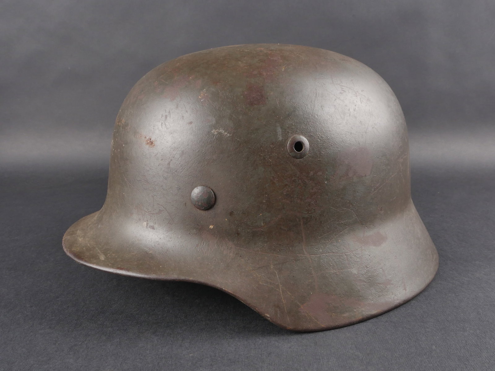 Casque allemand. German Helmet.: Casque allemand. Coque M35. Fabrication NS63, numero de lot E141. Coiffe en cuir complete presentant des marques d’usure. Dechirures visibles au niveau des dents de loup. Cordon de serrage arriere p