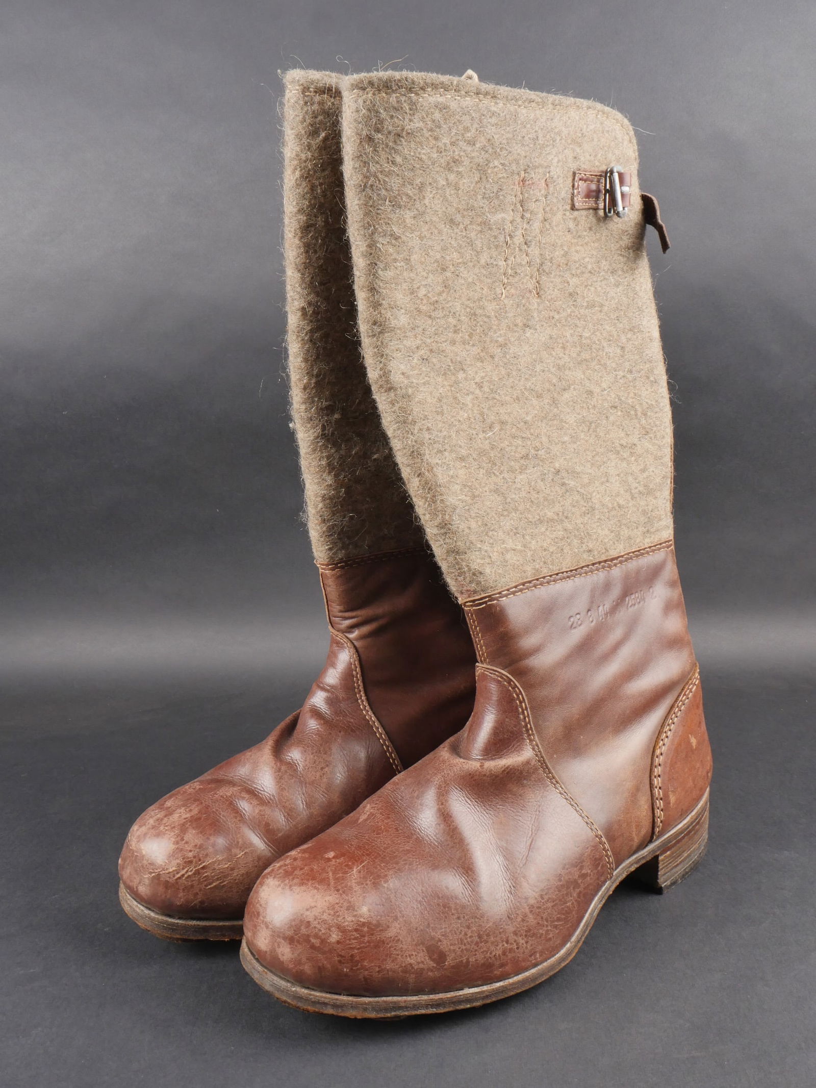 Bottes en feutre allemande. German felt boots: Bottes hivernales en feutre avec tiges hautes en epais feutre gris. Cuir marron souple et en tres bon etat. Les pattes de fermeture sont completes. Semelles en cuir avec renforts en cuir ajoutes pour