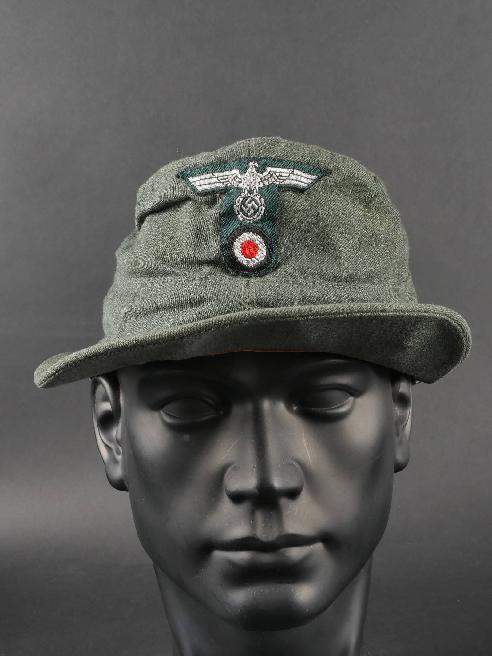 Casquette Heer. German Visor cap.: Casquette de la Heer, modele de fabrication fantaisie en fin tissu feldgrau. Insigne metallique des Gebirgsjager cousu a la main. Insignes de la Heer, modele en T, egalement cousus main. Interieur dou