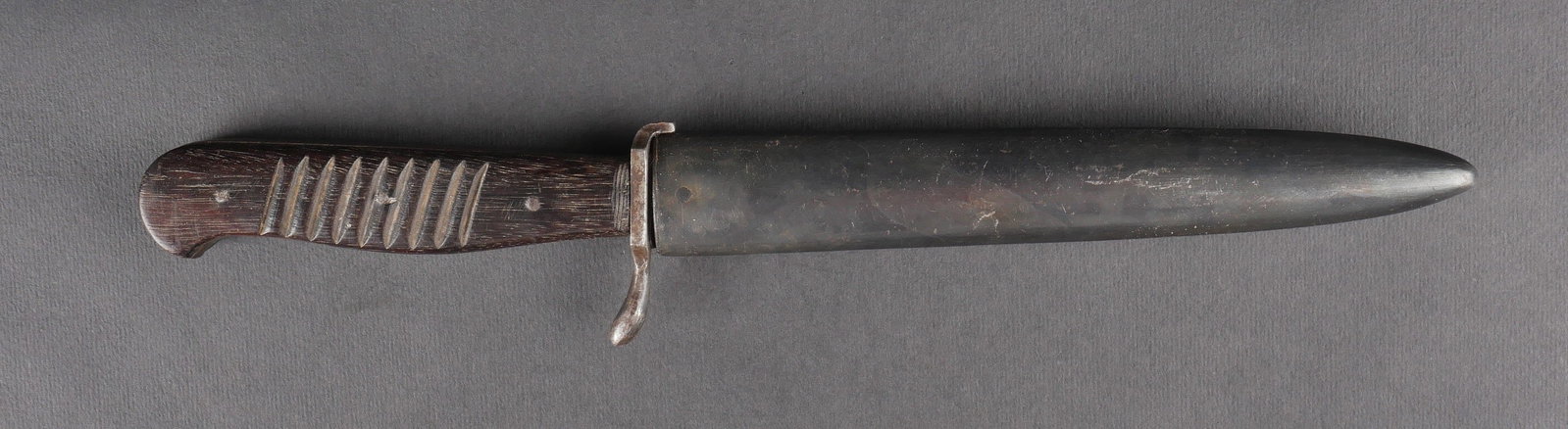 Couteau de botte. German Boot knife.: Couteau de botte allemand avec garnitures metalliques, plaquettes en bois strie fixees par trois rivets. Fourreau en metal dans sa teinte d’origine conservee a 80 %, crochets arriere presents. Lame 
