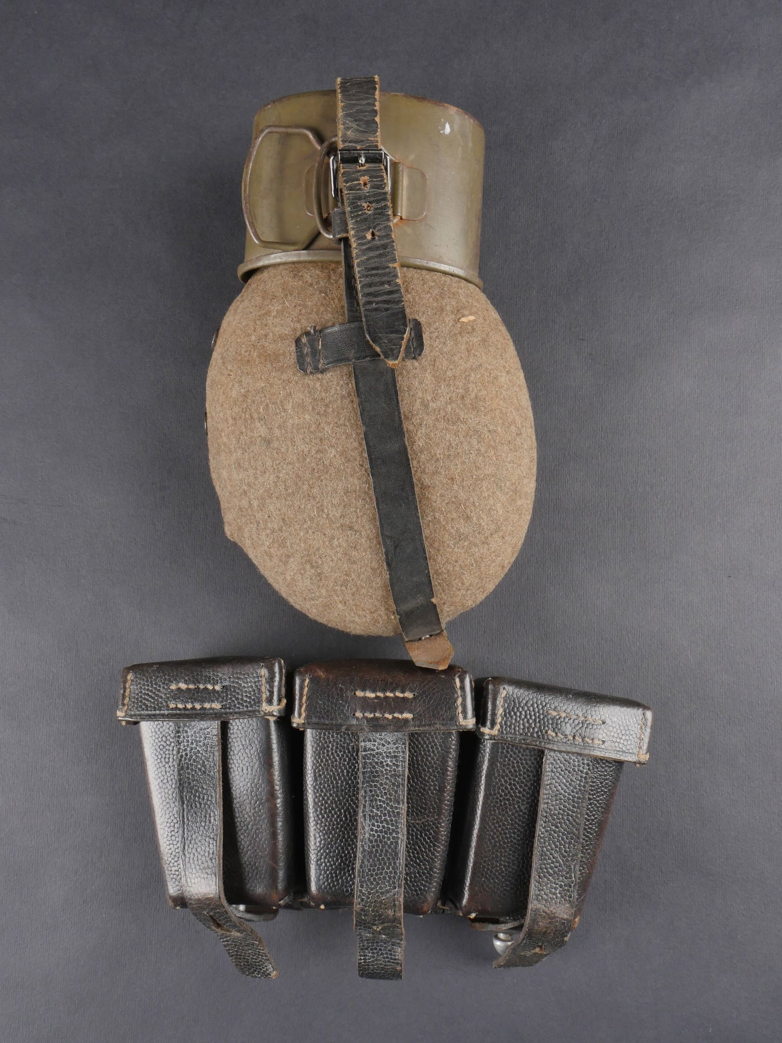 Gourde allemande. German canteen.: Gourde allemande. Realisee en aluminium, fabrication SSL 41. Bouchon en bakelite noire complet. Housse en feutrine Feldgrau. Boutons-pression fonctionnels. Harnais en cuir complet avec mousqueton fonc