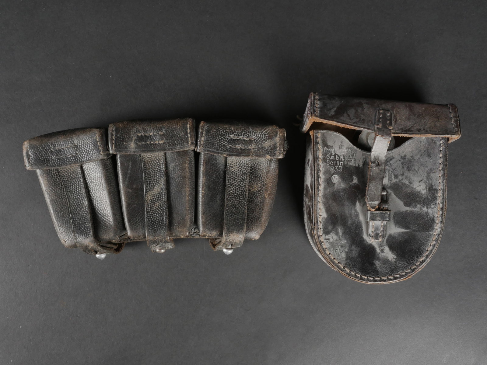 Equipement allemand. German equipment: equipement allemand. Comprend une cartouchiere Mauser 98K en cuir noir grenele, toutes attaches presentes, marquages partiellement illisibles (Neu Ulm, 1941). Une housse en cuir noir avec attache et p