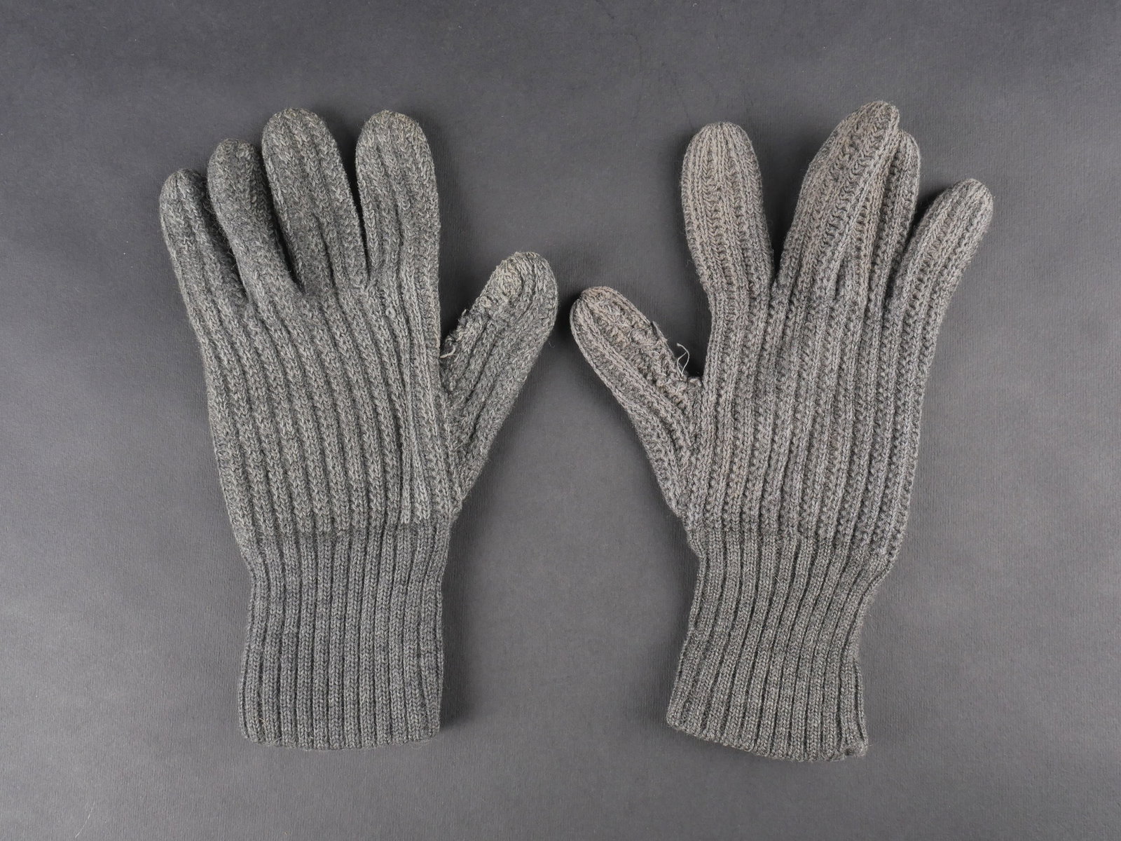 Gants allemand. German gloves.: Gants allemands. Paire non homogene en laine grise. Deux bandes blanches sur l’un des gants. Sans marquages visibles. a noter une certaine usure et patine des pieces ainsi que des reparations et acc