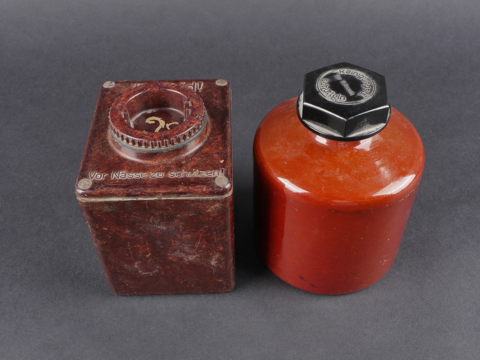 Filtres a carbure. German Carbide filters: Filtres a carbure. Ensemble comprenant un filtre en metal emaille marron avec bouchon en bakelite noire, portant l’inscription Reinigungsol vor Gebrauch Schutteln. Un reservoir a carbure en bakelite