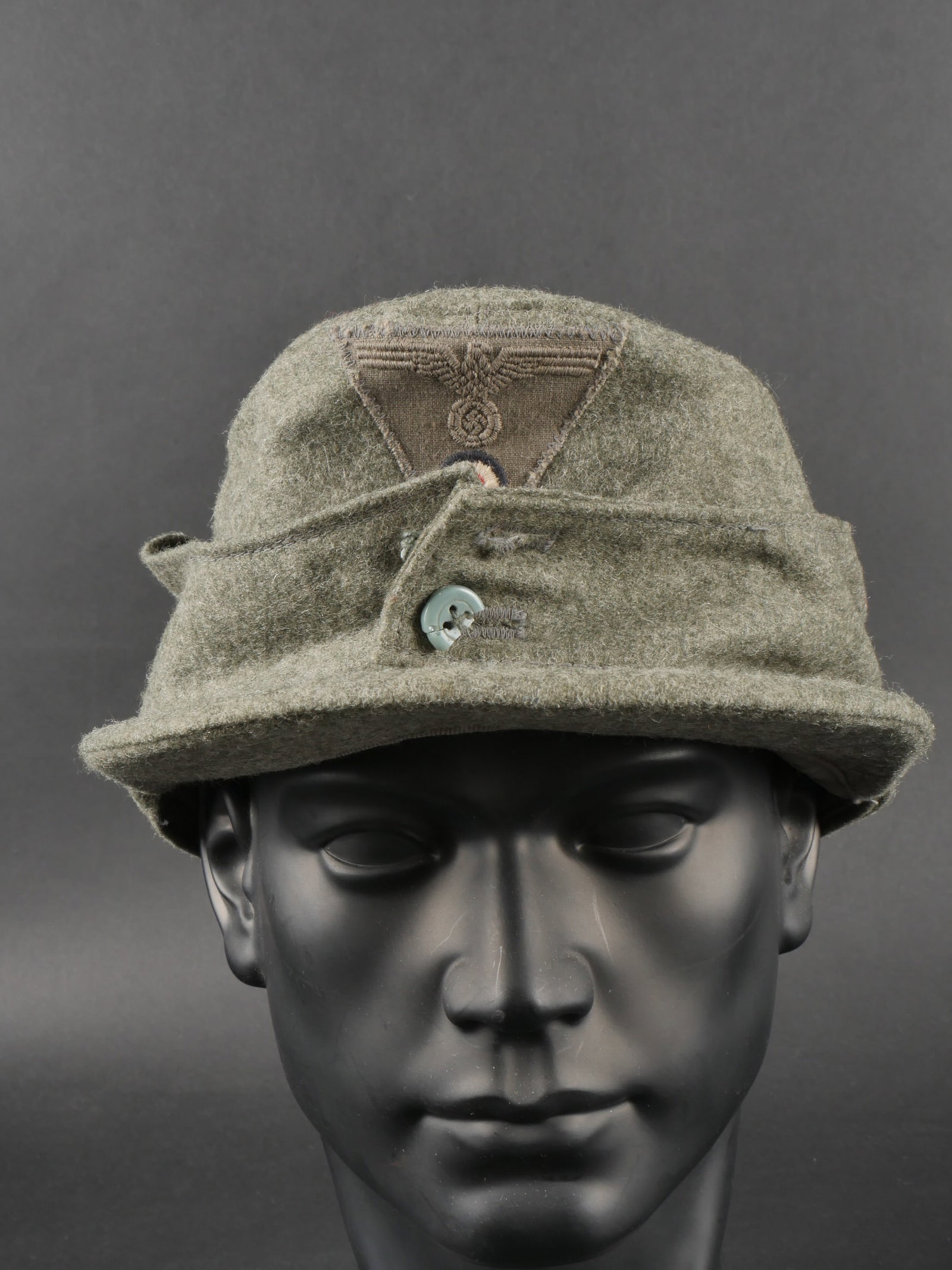 Casquette M-43 allemande. German M43 field cap: Casquette M43 allemande Realisee en drap Feldgrau les boutons des rabats sont casses insigne tisse modele de fin de guerre cousu a la machine visiere en bon etat interieur double en drap Feldgrau marq