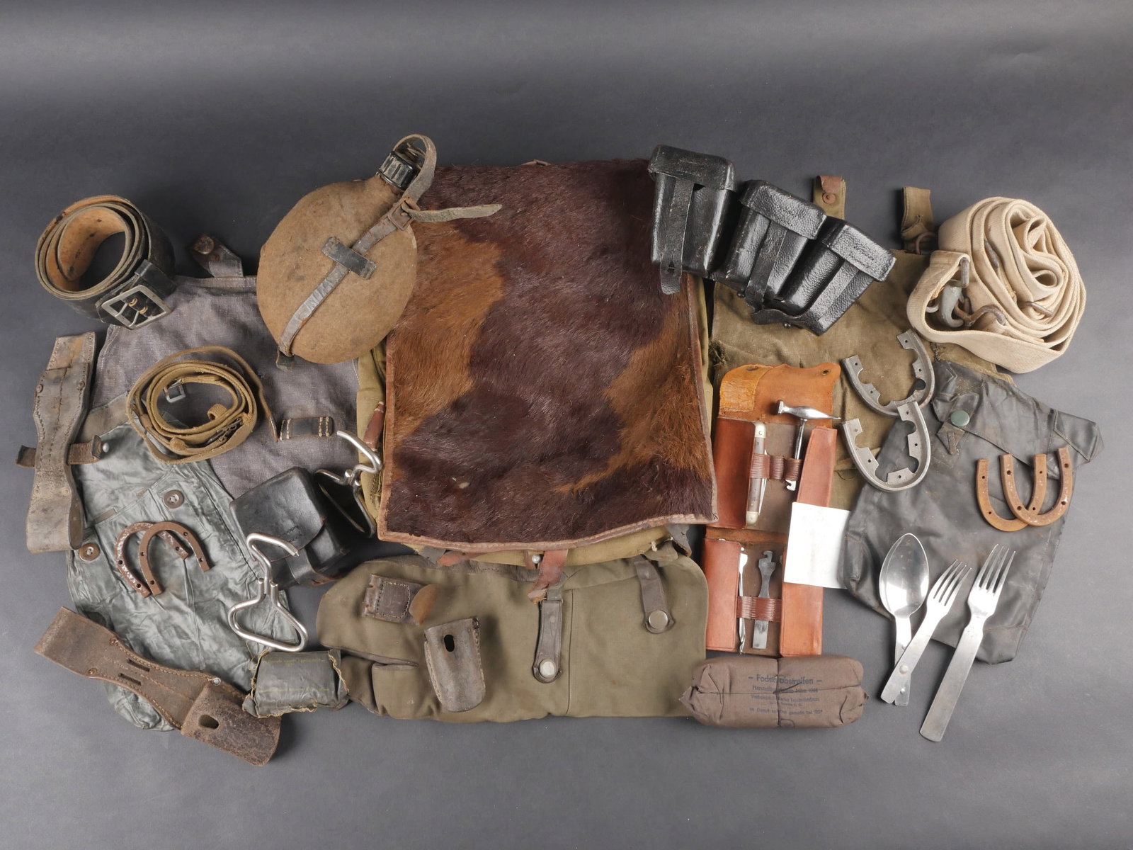Equipement allemand. German equipment.: equipement allemand comprenant un gousset en cuir pour baionnettes 98K, fortement use, avec des marquages illisibles. Une gourde en metal emaille avec bouchon complet et housse mitee. Un harnais en cu