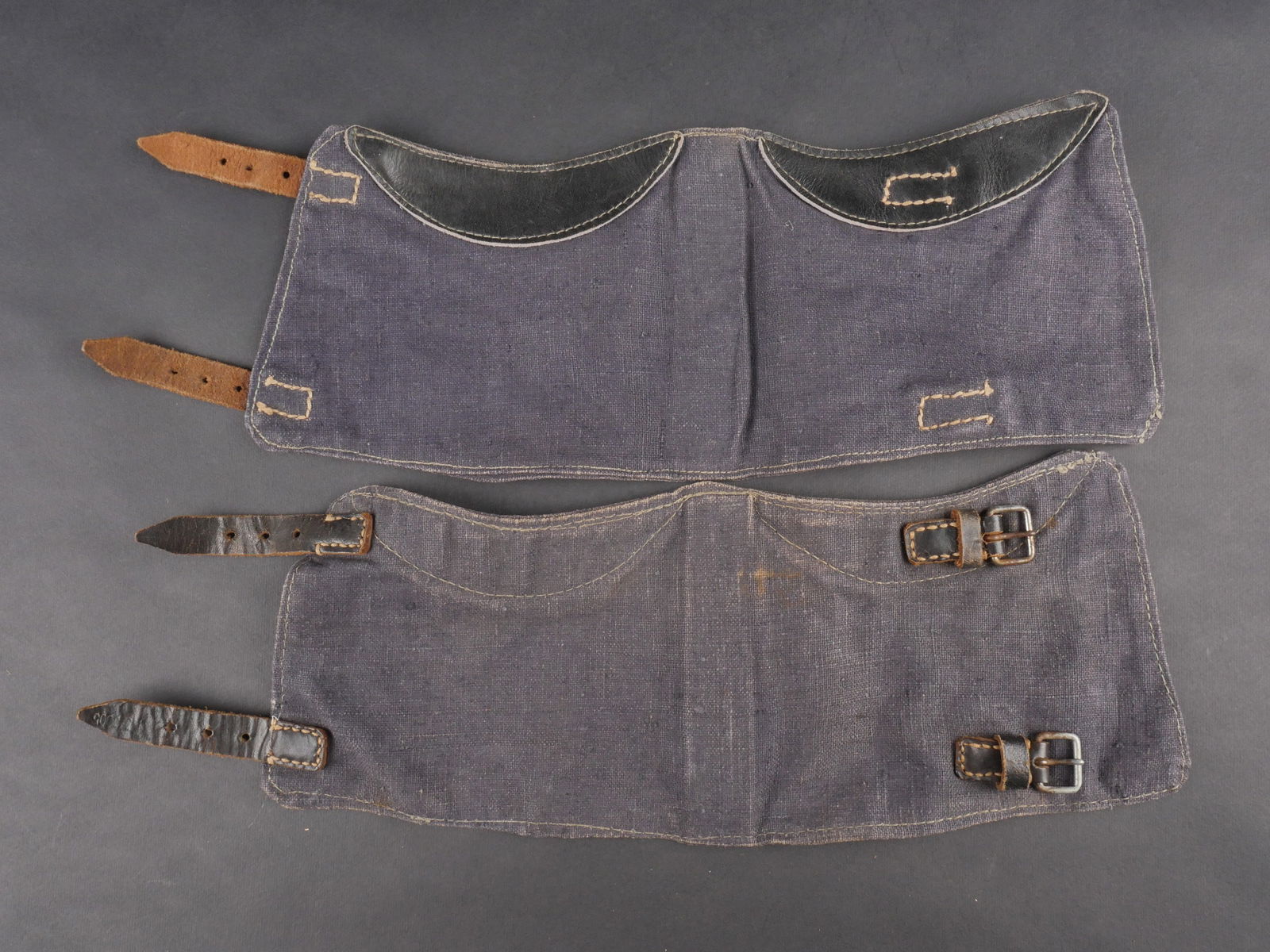 Guetres de la Luftwaffe. Luftwaffe gaiters.: Guetre de la Luftwaffe. Paire homogene en tissu coton gris-bleu, renforts en cuir noir. Sangles de fermeture en cuir noir. Sans marquages visibles. a noter une legere usure et patine de la piece. etat