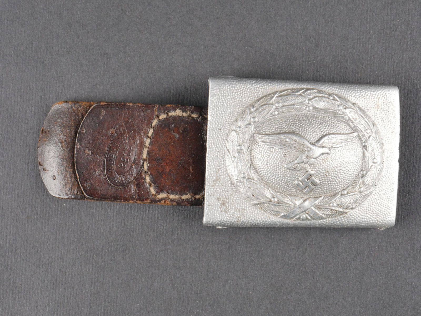 Boucle de ceinturon LW. Luftwaffe Belt buckle.: Boucle de ceinturon de la Luftwaffe. En aluminium, aigle du second type. Fabrication RS&S. Boucle a deux ardillons complete. Patte en cuir presente. Fabrication illisible, datee 1936. a noter une cert