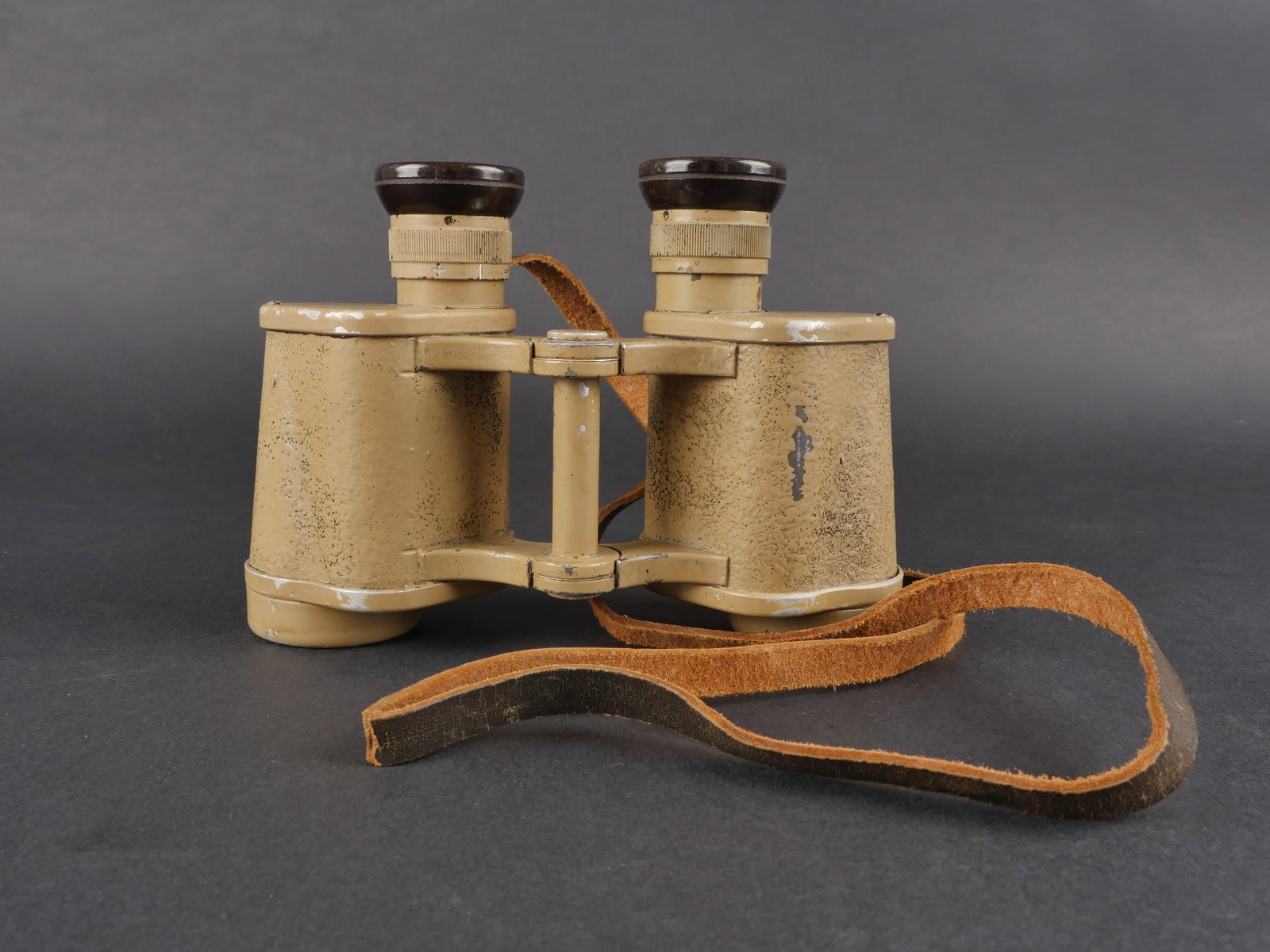 Jumelles 6 x 30. German 6 x 30 binoculars.: Jumelles 6 × 30 en metal peint couleur sable conservee a 80 %. Marquages CAG Dienstglass 6 × 30 112538 H/6400. Sangle de transport complete mais usee. Optique claire et graduee avec quelques taches.