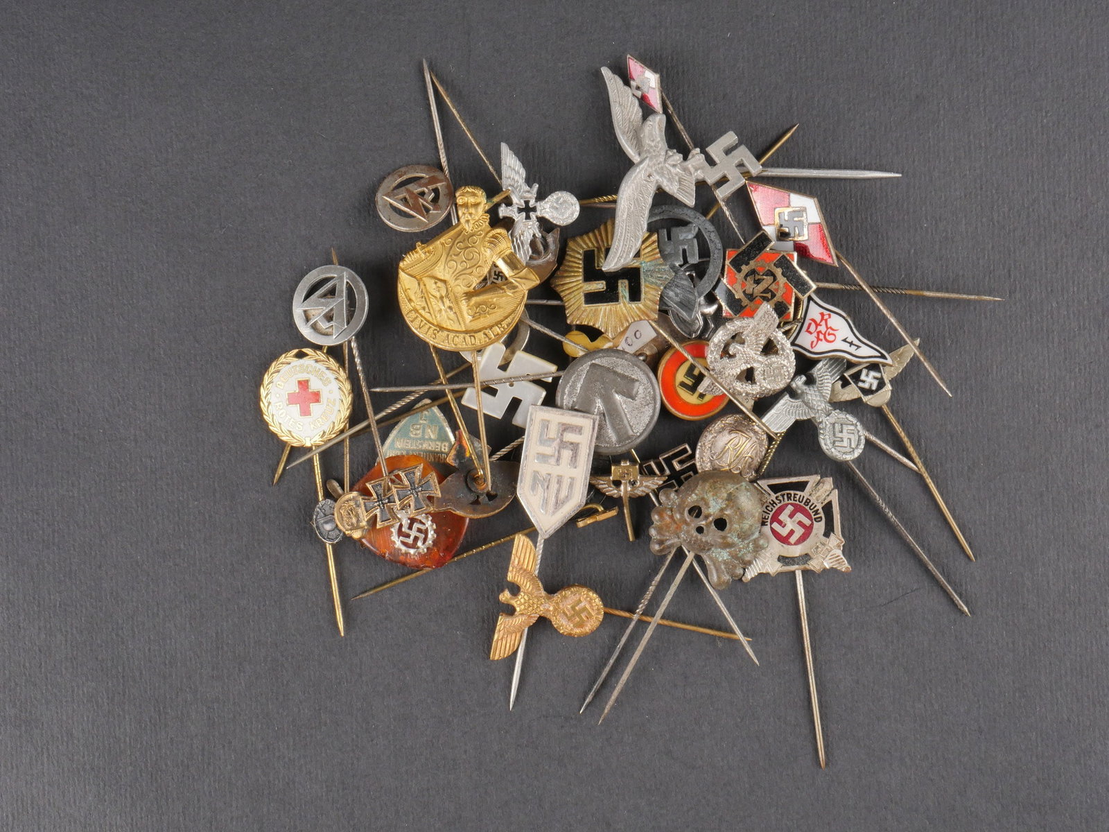 Epingles allemande. German lapel pins.: Ensemble de 40 epingles allemandes de modeles et fabrications varies. La majorite des attaches est presente. Presence d’une usure et d’une patine sur les pieces. etat II+. Set of 40 German pins of