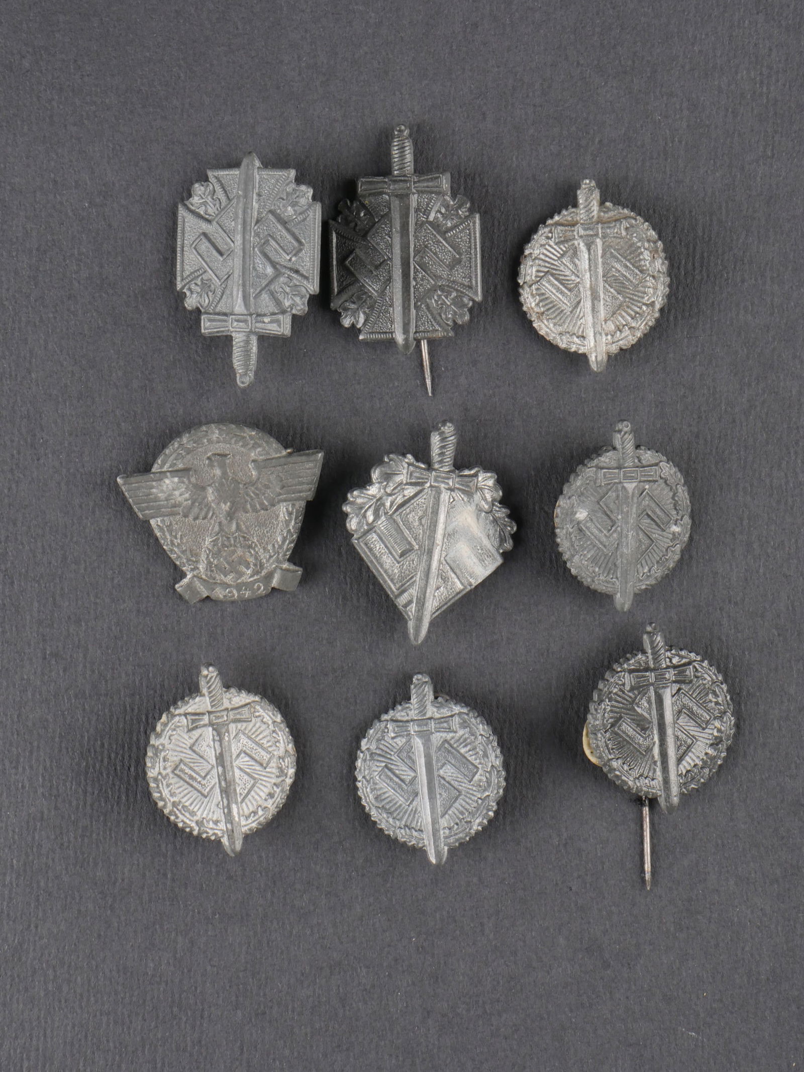 Insignes Tag der Wehrmacht. Tag der Wehrmacht badges.: Lot de neuf insignes Tag der Wehrmacht de modeles et fabrications divers. Toutes les attaches sont presentes. Usure et patine homogenes. etat II+. Lot of nine Tag der Wehrmacht badges of various model