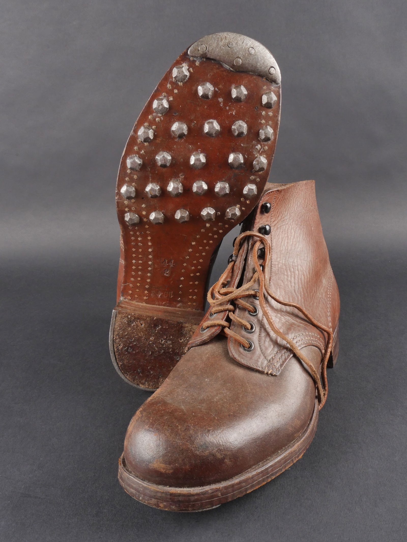 Brodequin allemand. German ankle boots.: Brodequins allemands, paire homogene en cuir lisse bicolore marron. Modele a quatre œillets et quatre crochets de lacage. Lacets en cuir presents. Taille estimee a 44. Semelles en cuir cloutees, talo