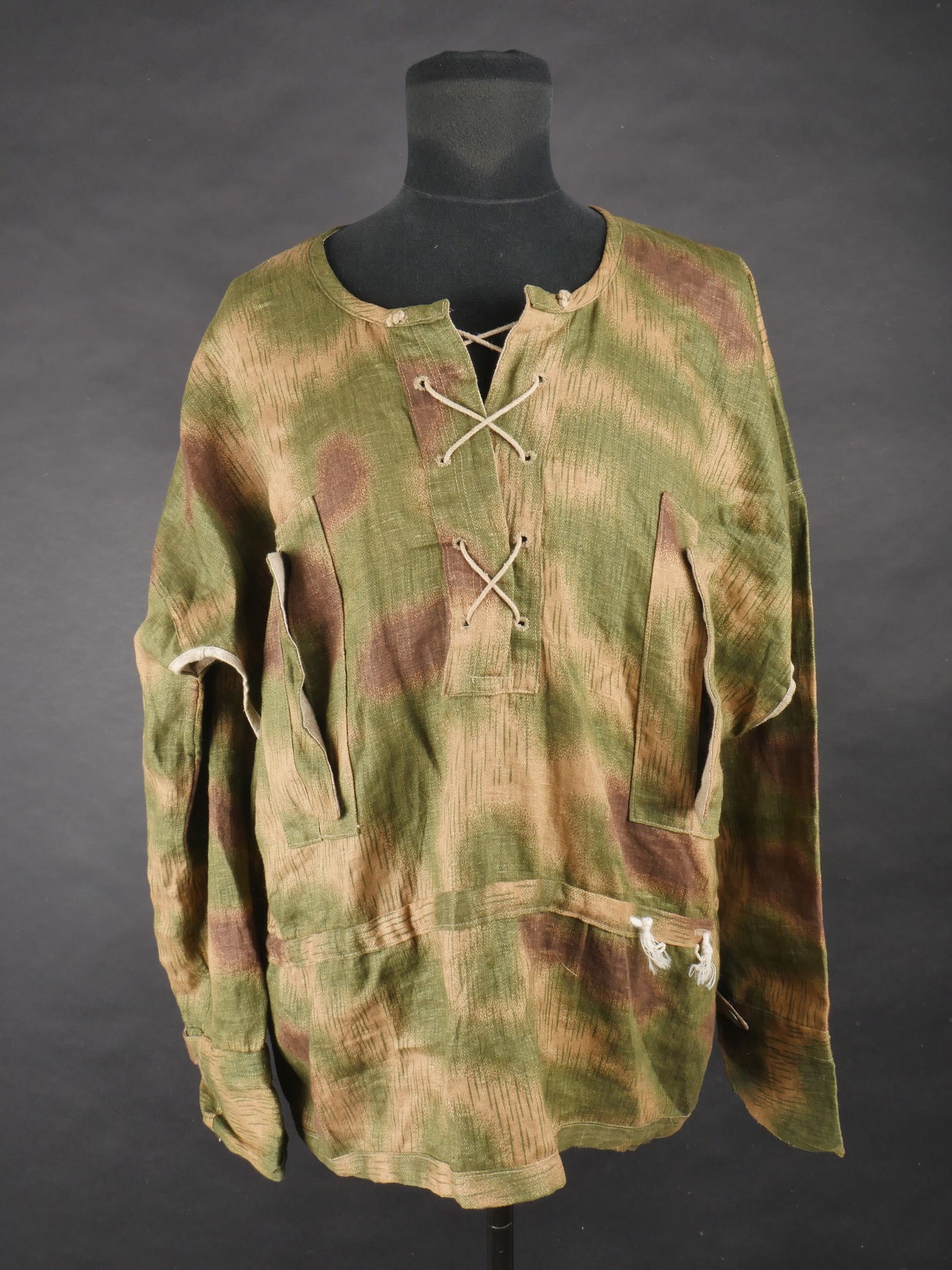 Blouse camoufle Heer. Heer camouflage blouse.: Blouse camouflee Heer. En tissu a camouflage flou. Non reversible. Cordon de serrage du col present. Ouvertures sous les aisselles. Deux poches au niveau des hanches. Cordon de serrage a la taille pre