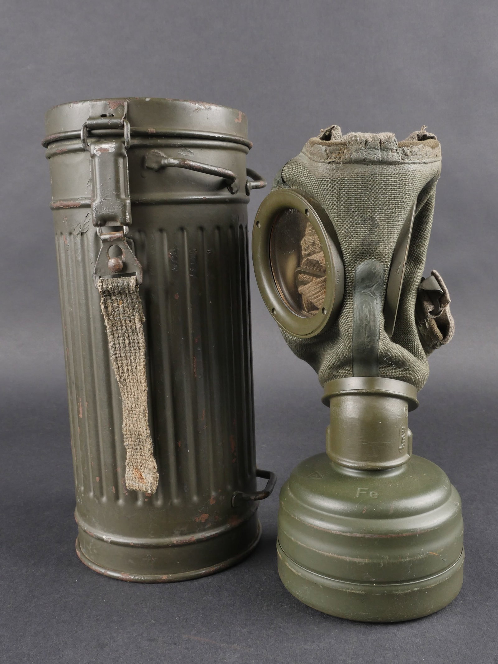 Masque anti-gaz allemand. German gas mask.: Masque anti-gaz allemand avec boitier long en metal peint en feldgrau a 80 %, repeint ou reconditionne. Numero 522 A inscrit a la peinture blanche sur le cote du boitier. Toutes les sangles sont manqu