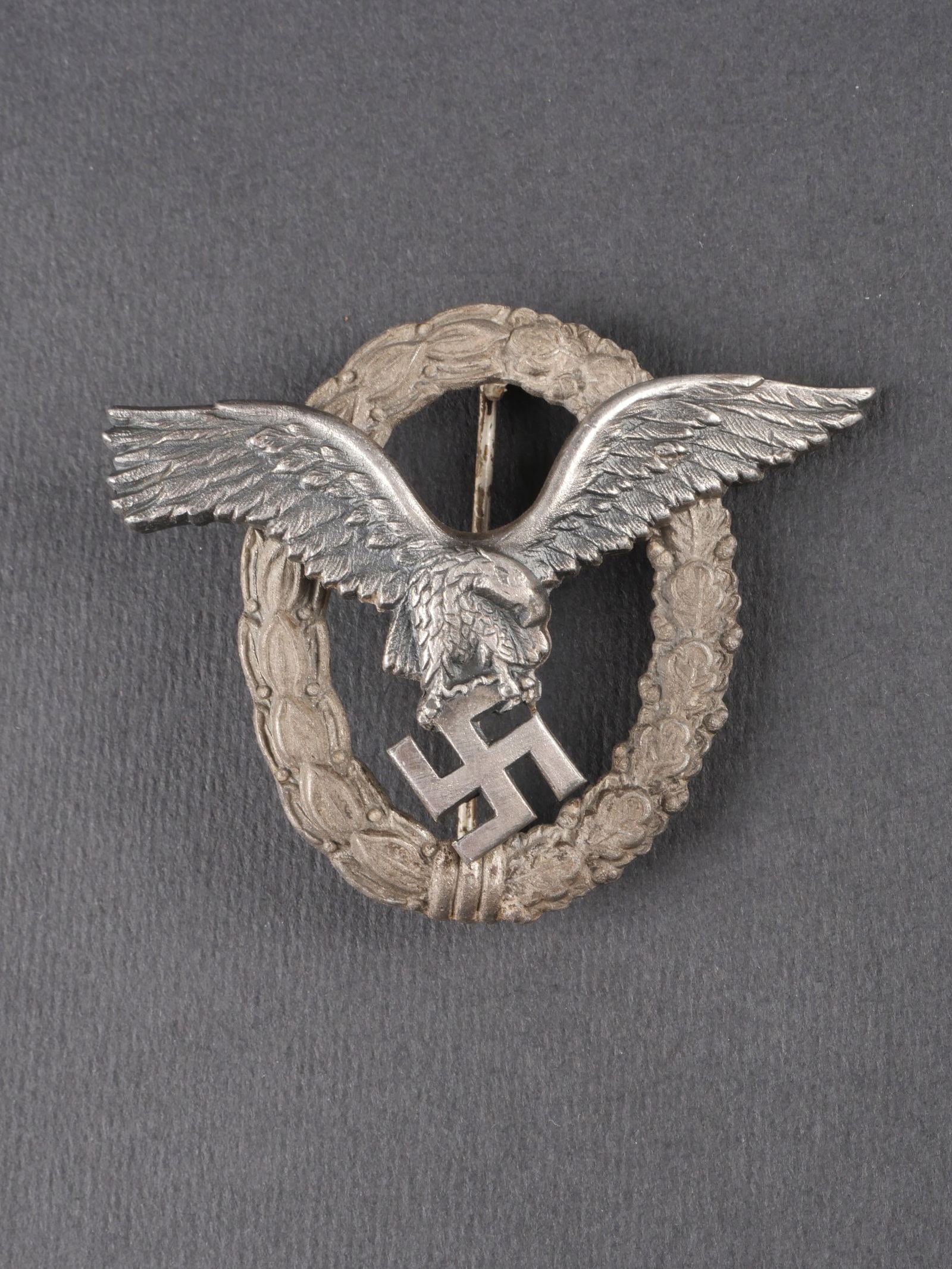 Brevet de pilote LW. Luftwaffe pilot badge: Brevet de pilote de la Luftwaffe en metal, fabrication en deux parties. Belle couleur argentee. Logo du fabricant BSW visible. Attache complete. a noter une certaine usure et patine de la piece. etat