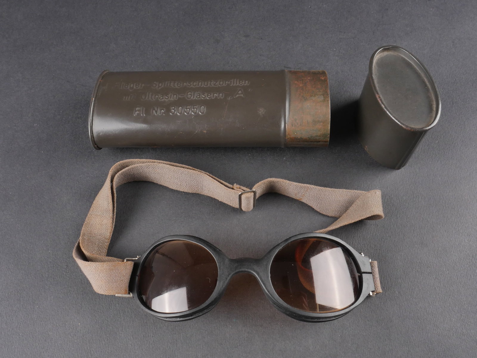Lunette de vol LW. Lufwaffe flight goggles.: Lunettes de vol de la Luftwaffe. Boite en metal complete avec couvercle. Marquages « Flieger Splitterschutzbrillen mit Ultrasn-Glasern A FL NR 30550 ». Peinture conservee a 70 %. Quelques bosses vis