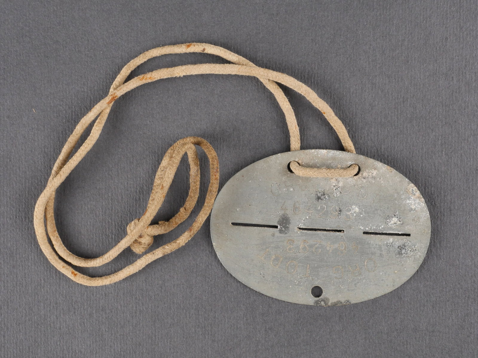 Plaque d identite Organisation Todt. Organisation Todt dog tag.: Plaque d’identite de l’Organisation Todt en metal, complete, marquee ORG TODT 464293. Cordon d’origine present et intact. Presente une certaine usure et patine. etat II+. Organisation Todt metal