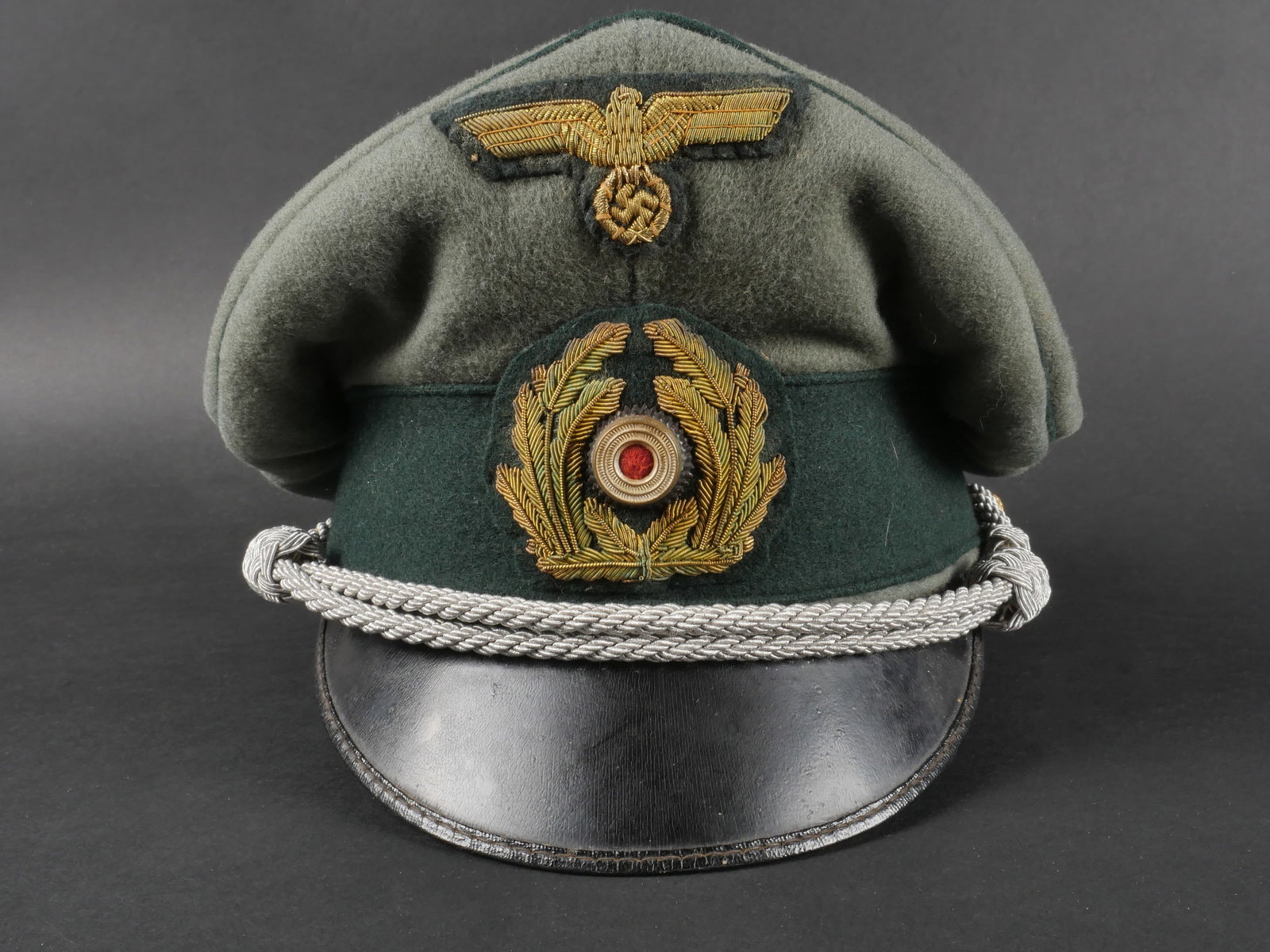Casquette artillerie cotiere. Coastal artillery cap: Casquette de l’artillerie cotiere. Coiffure confectionnee en epais drap Feldgrau, ornee d’un lisere vert fonce sur tout le pourtour. Le bandeau est realise en velours vert fonce. Les insignes, en 