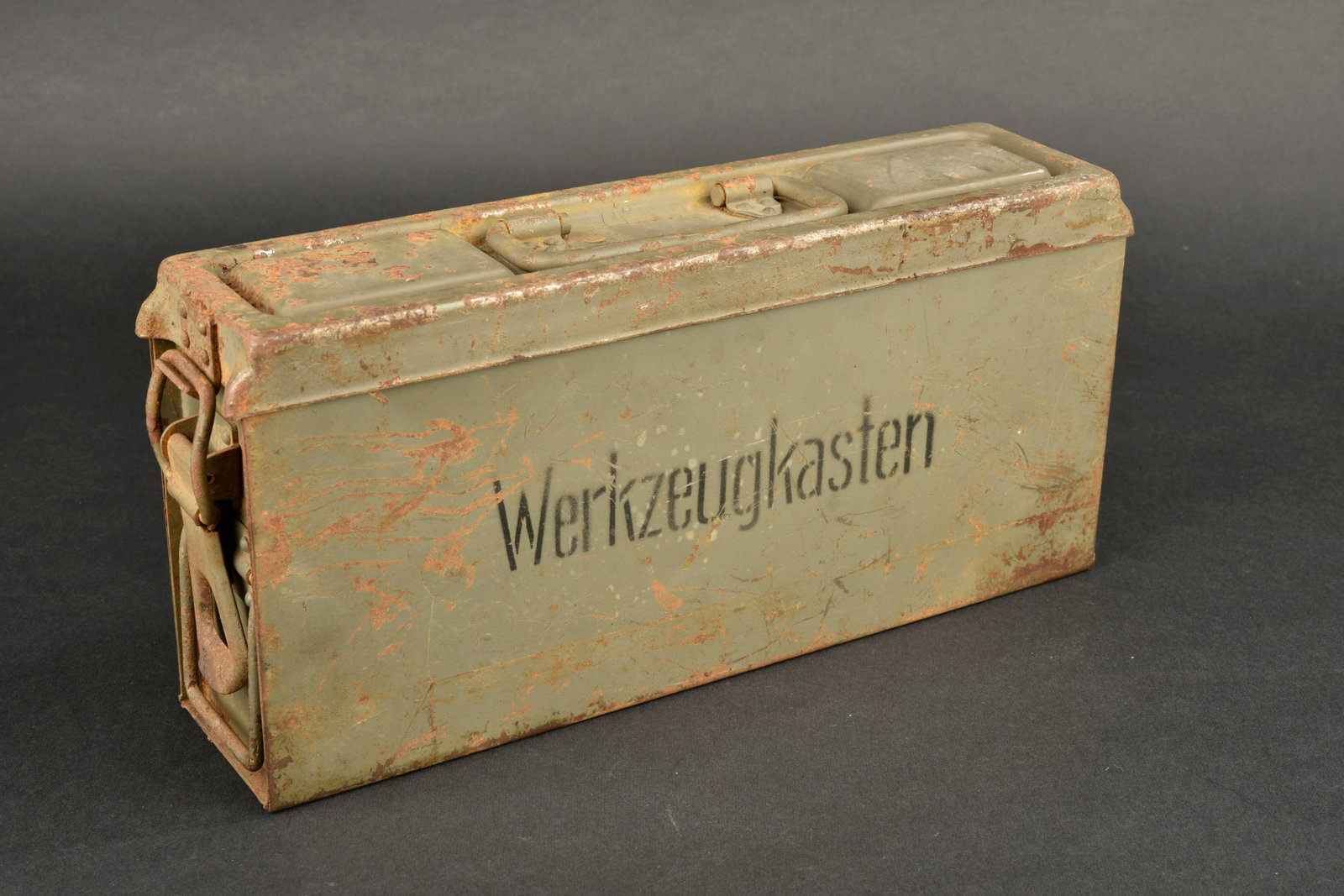 Caisse Werkzeugkasten KM. Kriegsmarine toolbox.: Caisse Werkzeugkasten de la Kriegsmarine. Caisse en metal, peinture gris bateau a 70 %. Marquages au pochoir « Werkzeugkasten ». Le crochet de fermeture est fonctionnel, poignee de transport present