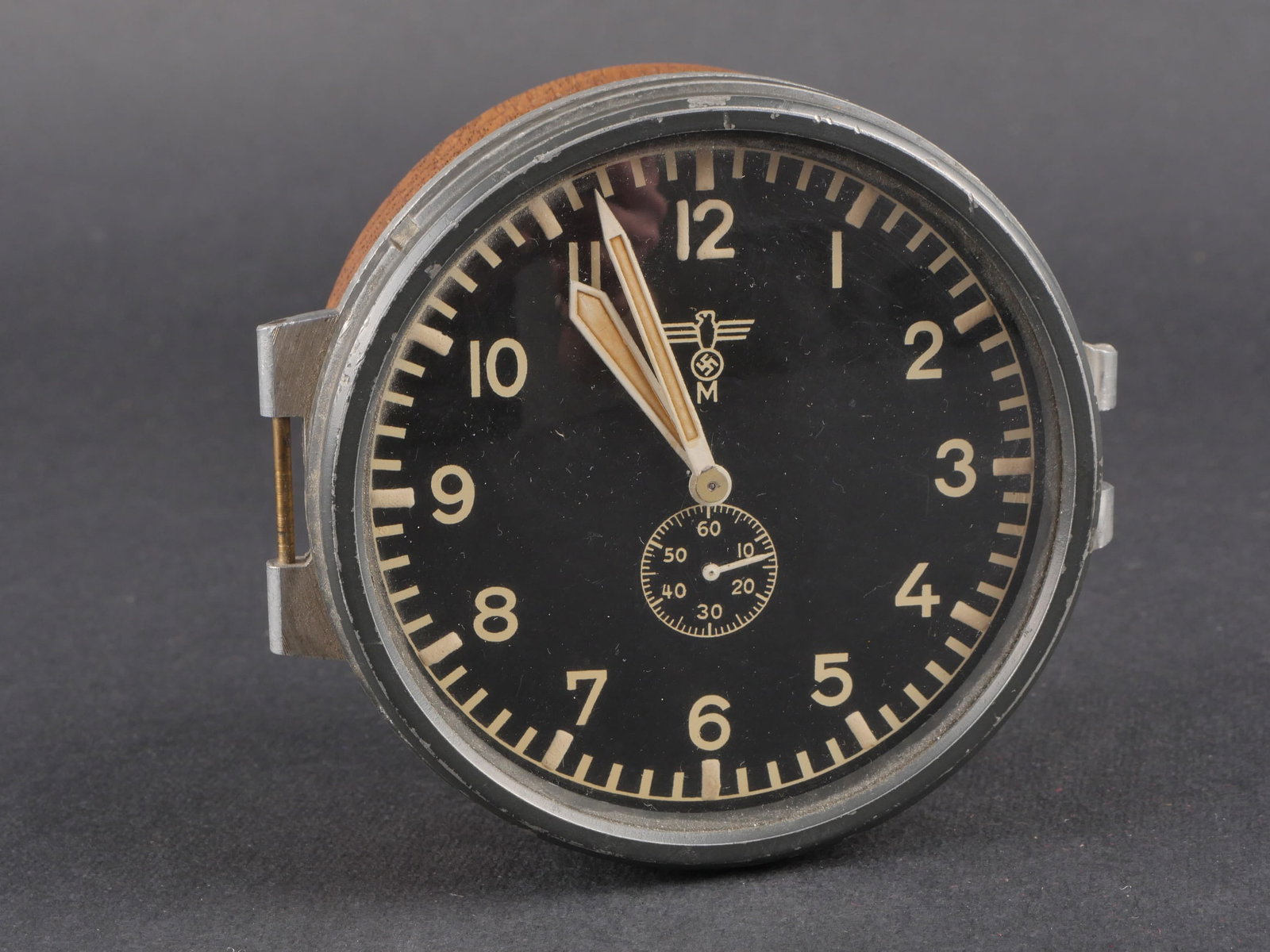 Montre Kriegsmarine. Kriegsmarine watch.: Montre de bord de la Kriegsmarine, bel instrument en metal avec cadran noir et aiguilles presentes. Bel aigle de la Kriegsmarine visible. Marquages au dos Junghans J 30E. Traces de colle visibles au d