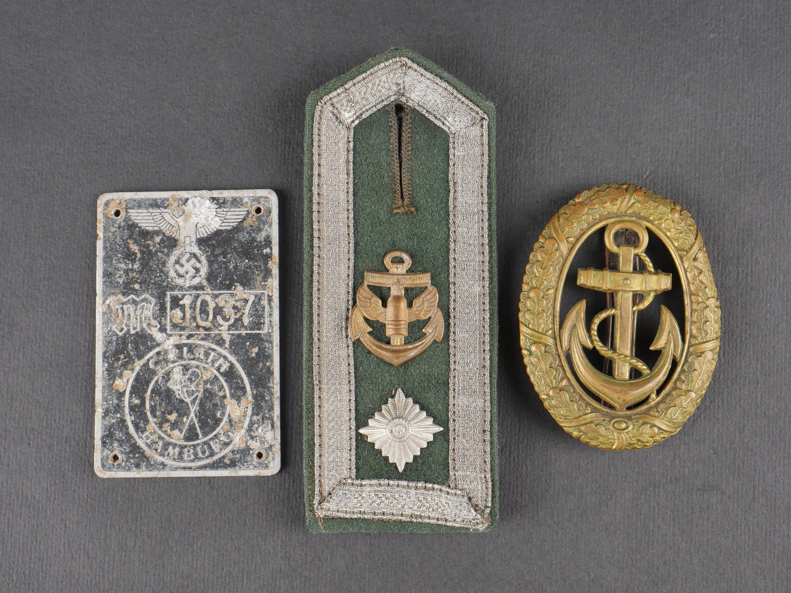 Insignes Kriegsmarine. Kriegsmarine insignia.: Insignes de la Kriegsmarine comprenant une patte d’epaule de Bootsmann, une plaque en aluminium ornee d’un bel aigle allemand, marquee M 1037 C Plath Hamburg, ainsi qu’un insigne d’officier de