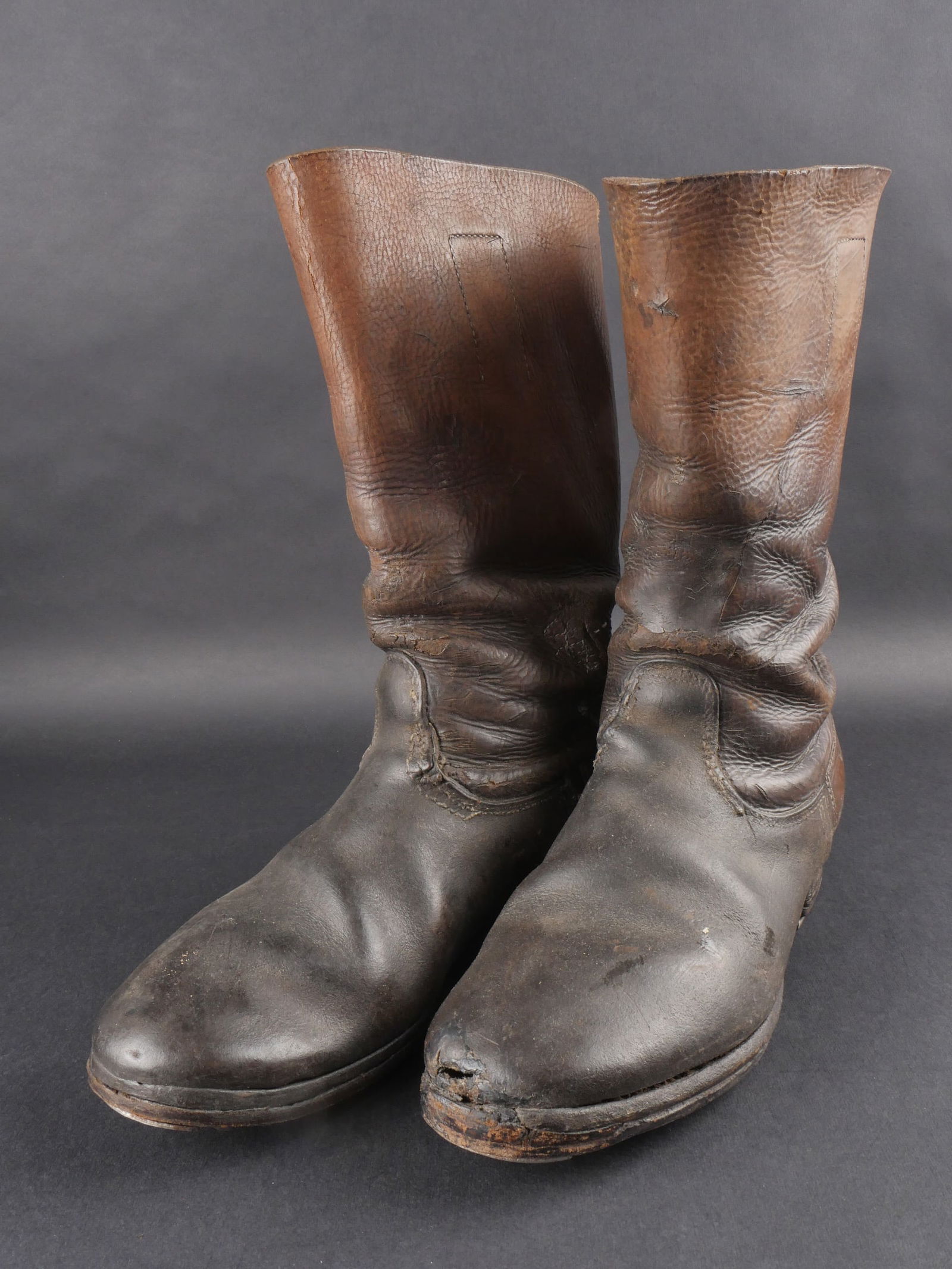 Bottes SS. German SS Boots.: Paire homogene de bottes SS en cuir fauve a tiges courtes, correspondant approximativement a une pointure francaise 41/42. Une reparation d’epoque est visible a l’arriere de l’une des bottes. Ma