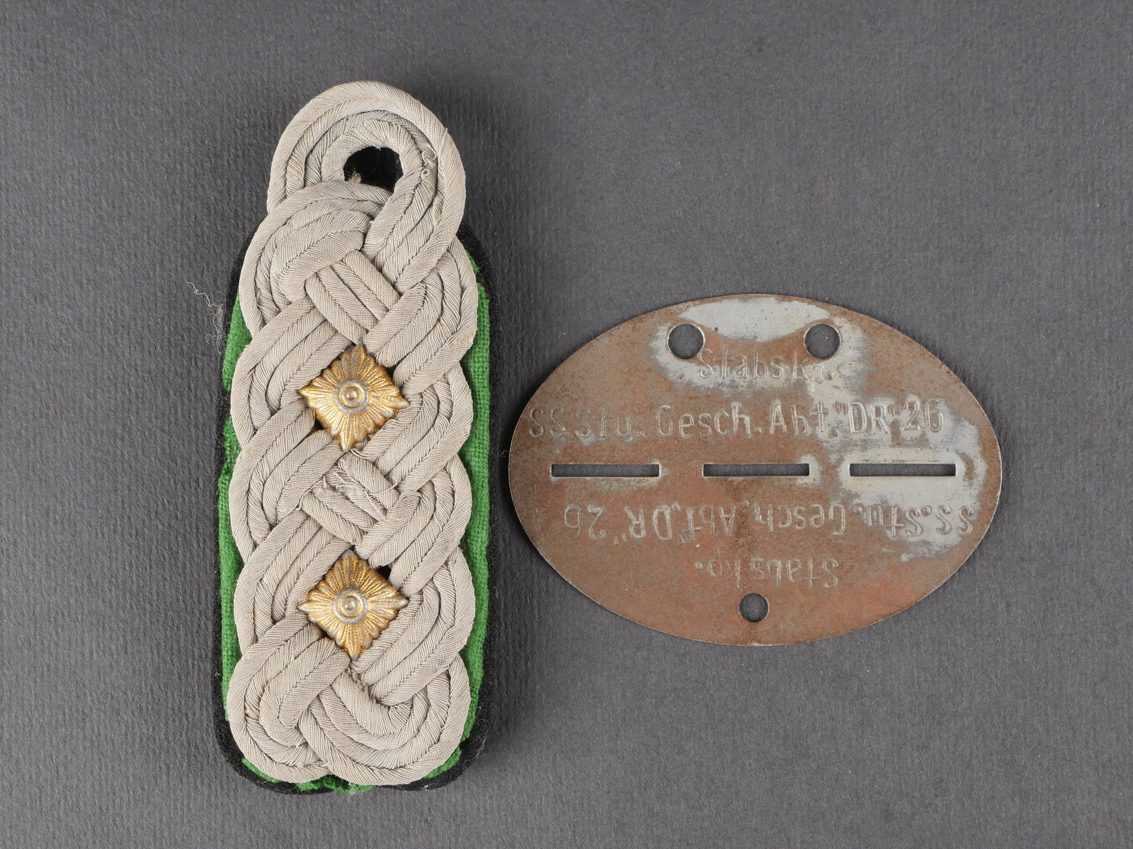 Accessoires SS. German SS accessories.: Accessoires SS comprenant une patte d’epaule de Standartenfuhrer avec socle vert et noir, en bon etat. Deux clous de grade metalliques dores. Une plaque d’identite en metal bien marquee Stabs KP S
