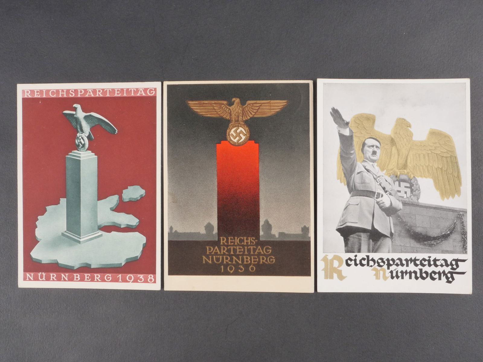 Cartes postales Reichsparteitag. Reichsparteitag Postal cards.: Trois cartes postales du Reichsparteitag, modeles differents, deux avec textes manuscrits au verso. Modeles en couleur. Legere usure et patine. etat I?. Three different Reichsparteitag postcards, two