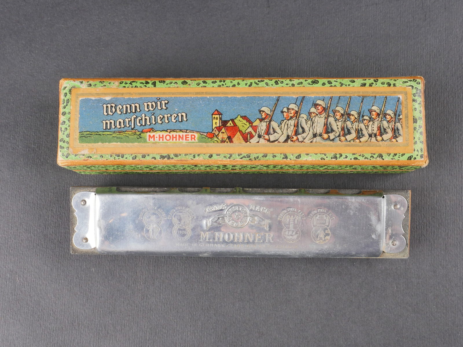 Harmonica allemand. German harmonica: Harmonica allemand. En metal, dans sa boite en carton originale et complete. Fabrication Hohner Wenn Wir Marschieren. A noter une certaine usure et patine de la piece. Etat II+. German Harmonica. Meta