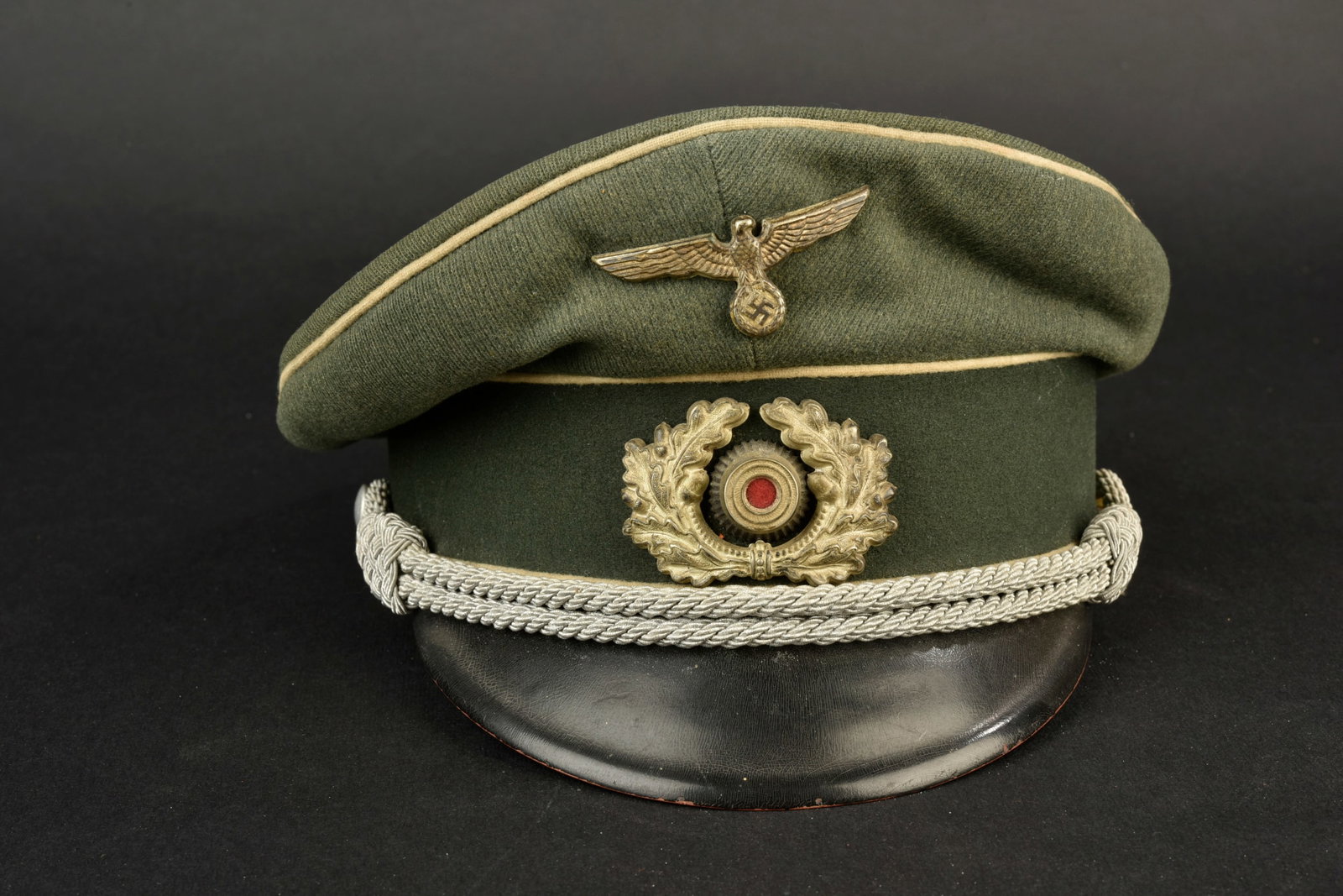 Casquette d officier d infanterie de la Heer. En gabardine Feldgrau. Triple lisere blanc de l: Casquette d officier d infanterie de la Heer. En gabardine Feldgrau. Triple lisere blanc de l infanterie. Modele precoce. Bandeau en drap Feldgrau. Insignes metalliques. Les insignes n ont pas ete dem
