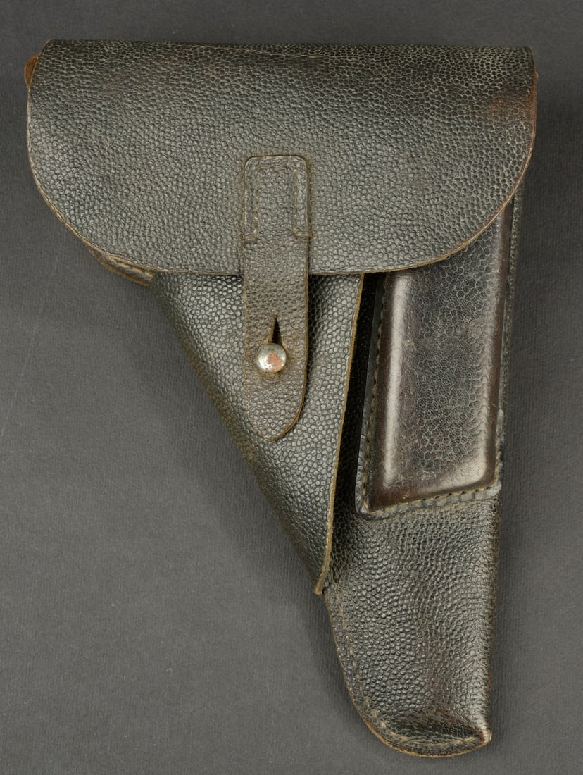 Holster de pistolet P38. Second modele en cuir noir grenele. La sangle de fermeture est complete.: Holster de pistolet P38. Second modele en cuir noir grenele. La sangle de fermeture est complete. Les passants au ceinturon sont presents. Marquages CCR 44. A noter une certaine usure et patine de la 