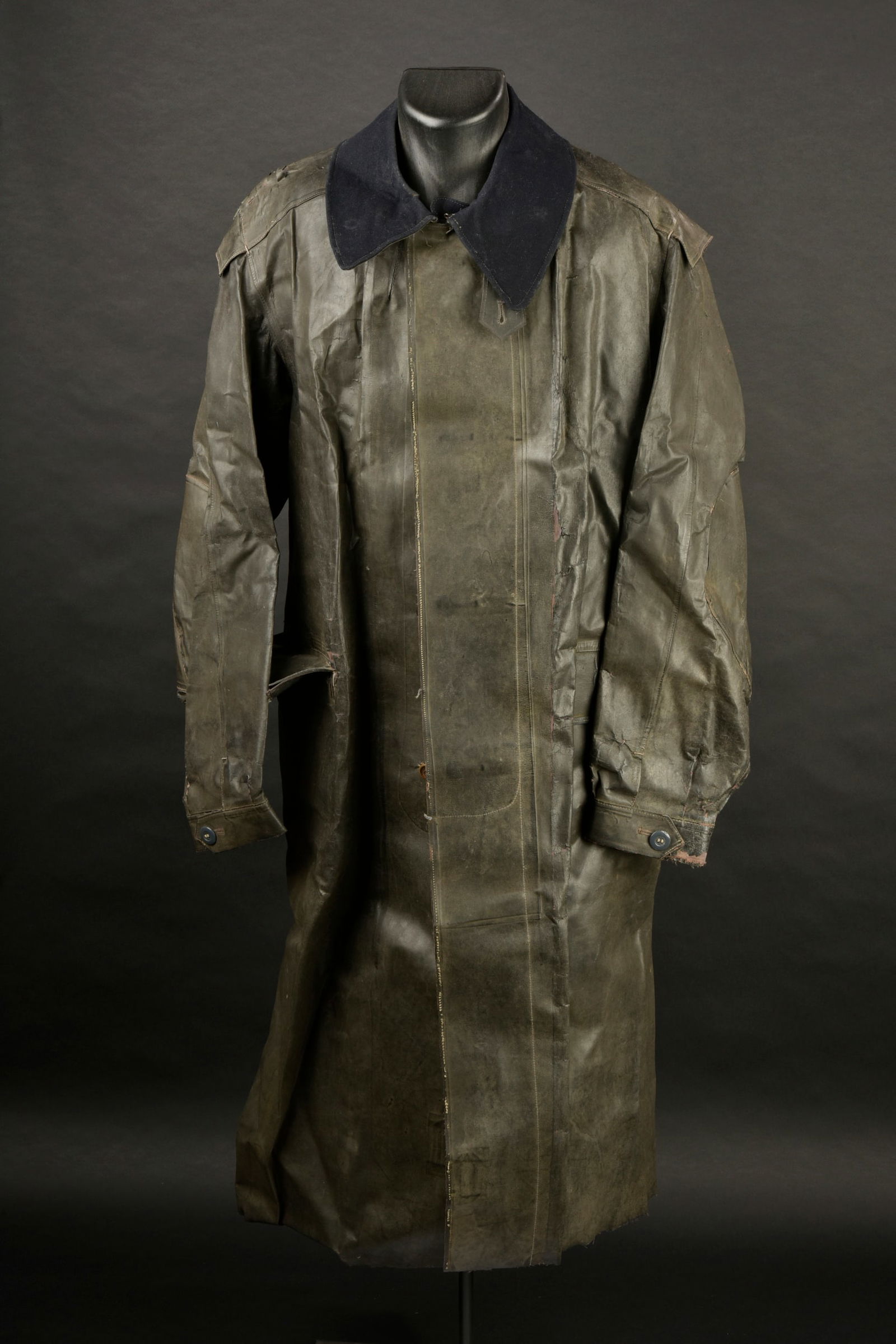 Keppler nominatif. En toile caoutchoute noire. La majorite des boutons sont presents. Col double en: Keppler nominatif. En toile caoutchoute noire. La majorite des boutons sont presents. Col double en drap bleu marine. Nombreux manques et accrocs. Interieur double en tissu coton gris. Marquages RBNr