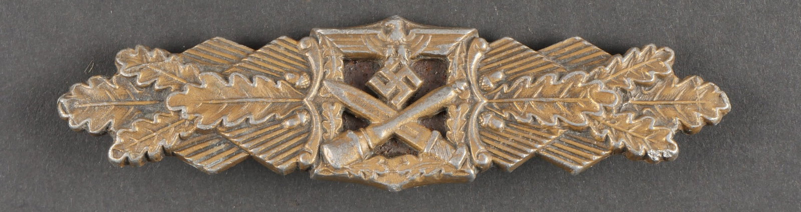 Barette de combat rapproche. En metal, couleur or a 80%. Attache complete. Fabrication AUSF AGM: Barette de combat rapproche. En metal, couleur or a 80%. Attache complete. Fabrication AUSF AGM Gablonz Fec WE Peekhaus Berlin. A noter une certaine usure et patine de la piece. Etat II+. Collection L