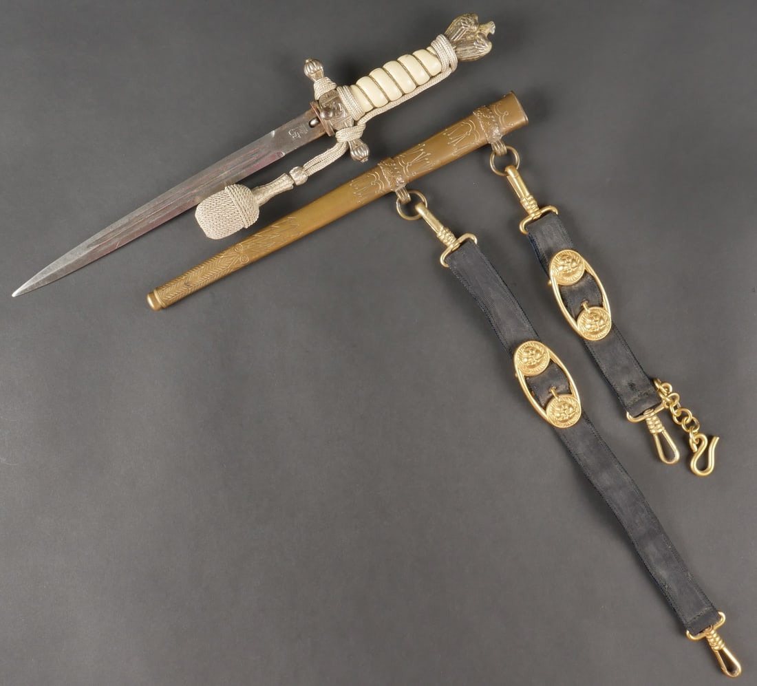 Dague d officier de la Kriegsmarine. Garniture en metal dore. La dorure est fortement usee par: Dague d officier de la Kriegsmarine. Garniture en metal dore. La dorure est fortement usee par endroit. Le bouton poussoir est fonctionnel. Poignee en celluloid blanche, celle-ci presente quelques man