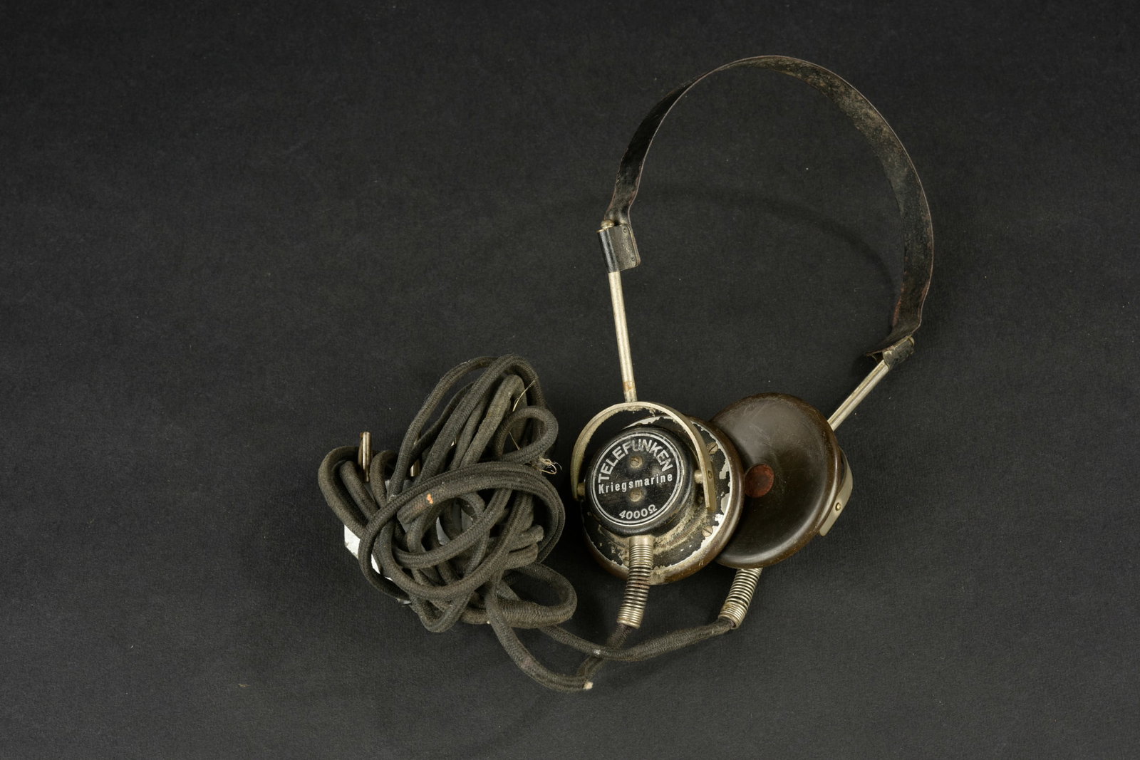Ecouteurs radio Kriegsmarine. Serre-tete en metal. Ecouteurs amovibles, dont l un est marque: Ecouteurs radio Kriegsmarine. Serre-tete en metal. Ecouteurs amovibles, dont l un est marque Telefunken Kriegsmarine 4000. Cable complet avec sa prise de couleur gris bateau. Fabrication Junker DRGM. 