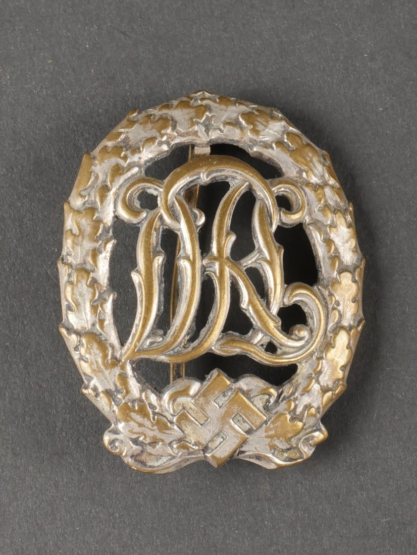 Insigne DRL. En metal, la couleur est quasiment absente. Attache complete, fabrication DRGM 35269: Insigne DRL. En metal, la couleur est quasiment absente. Attache complete, fabrication DRGM 35269 Wernstein Jena. A noter une certaine usure et patine de la piece. Etat II+. Collection Lemarchand Norm