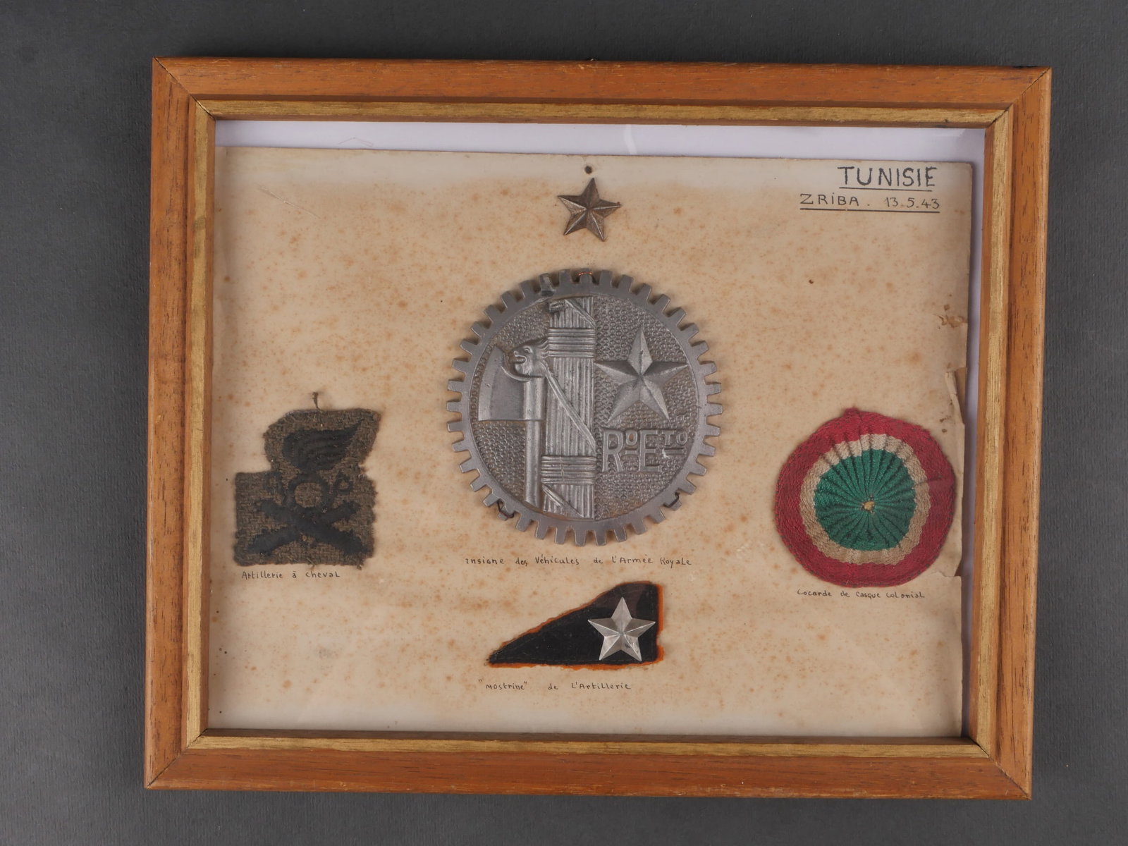 Insignes italien recupere par un compagnon de la Liberation. Italian insignia recovered by a: Insignes italiens recuperes par Edouard Meric Compagnon de la Liberation, le 13 mai 1943. Beau cadre ancien, planche cartonnee disposant des insignes de lArtillerie a cheval, un insigne de vehicule de