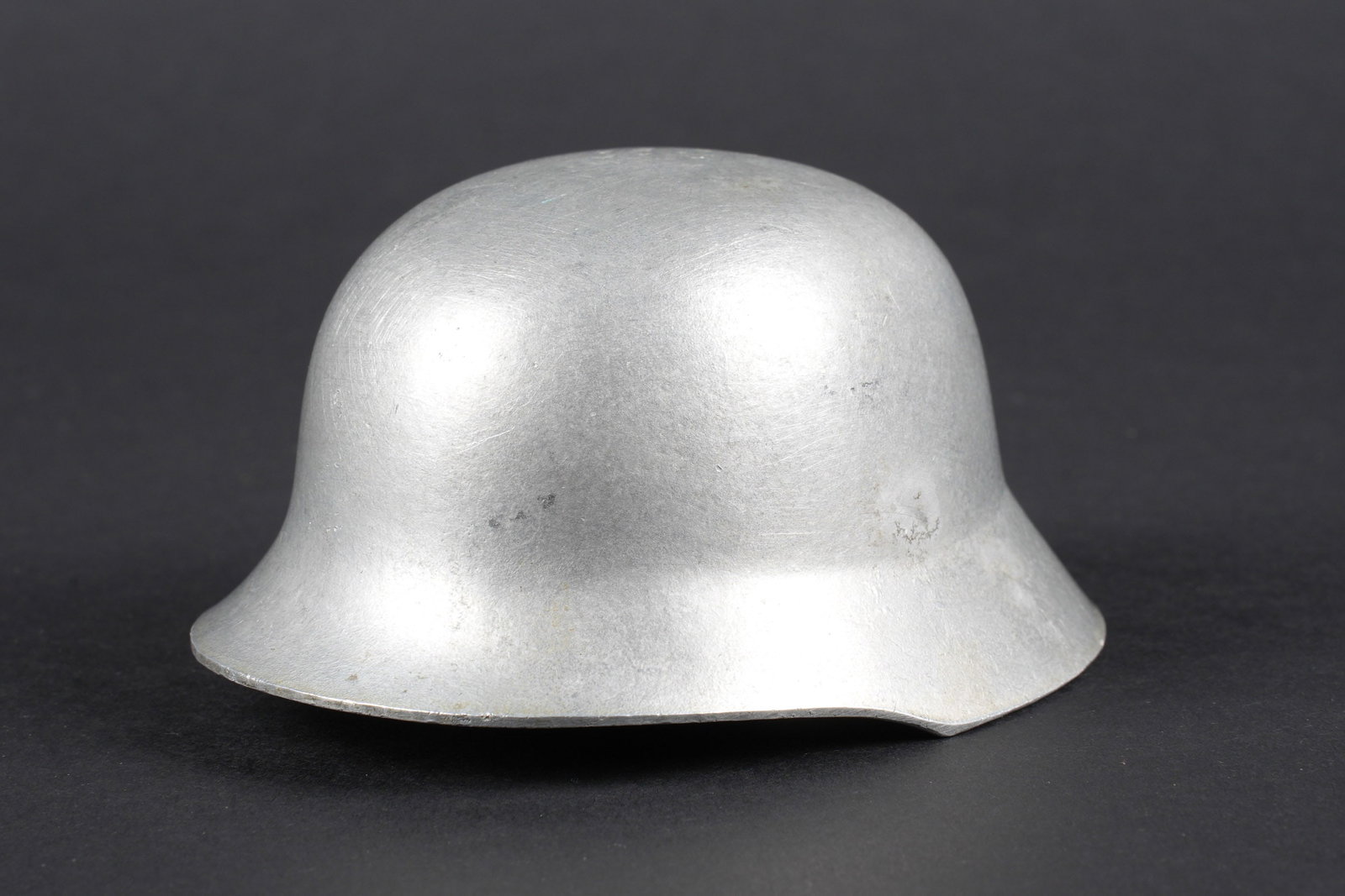 Decors de bureau. German office decorations.: Decors de bureau. Representation dun casque allemand miniature en metal, couleur argent, sans marquages visibles. Dimensions 9,6 x 8 x 5 cm. A noter une certaine usure et patine de la piece. Etat II+.