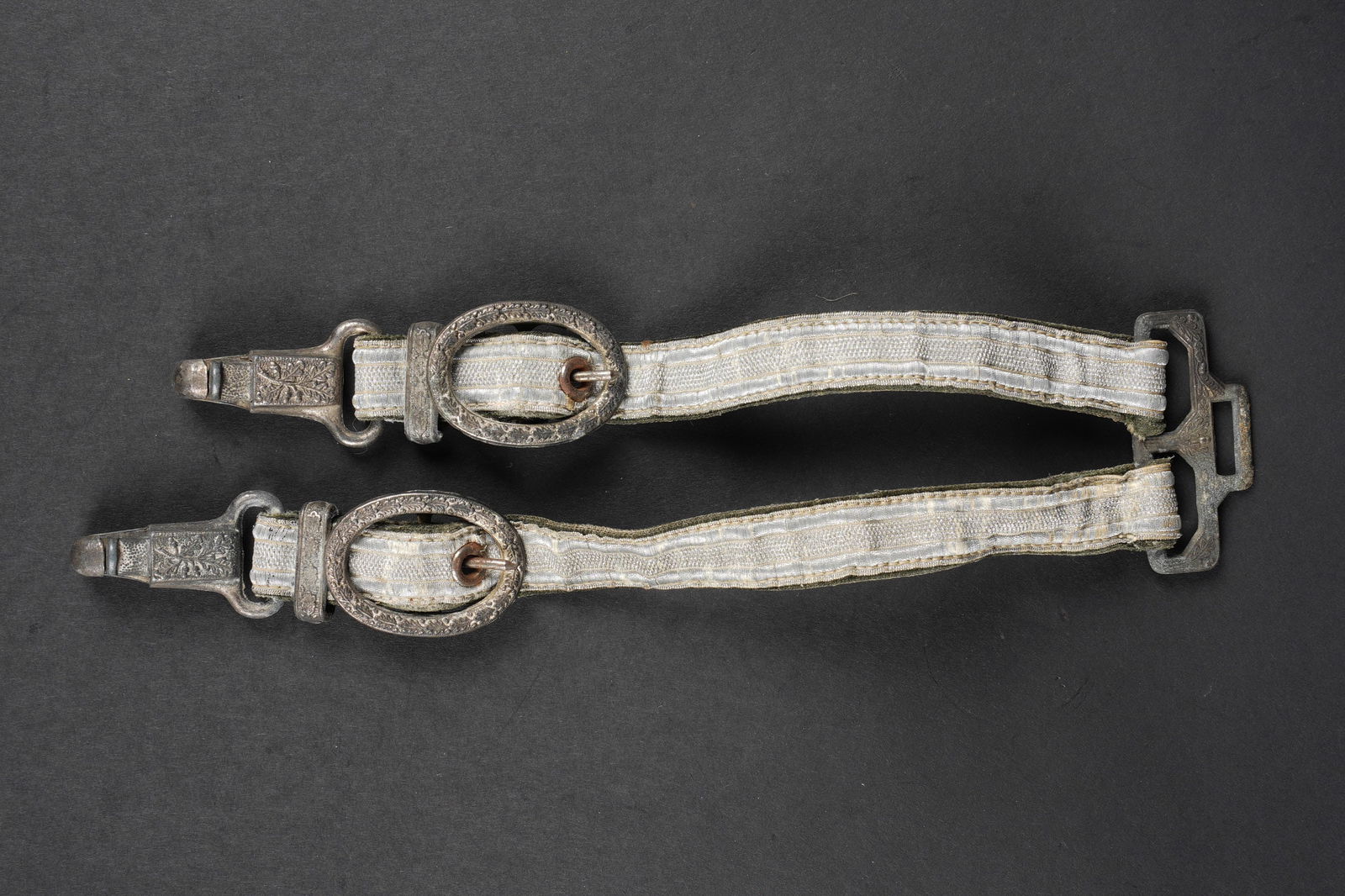 Belieres de dague. German dagger suspender.: Belieres de dague. Modele dit de luxe. Toutes les garnitures metalliques sont ornees de feuilles de chene. Les mousquetons sont fonctionnels. Fabrication DRGM. A noter une certaine usure et patine de