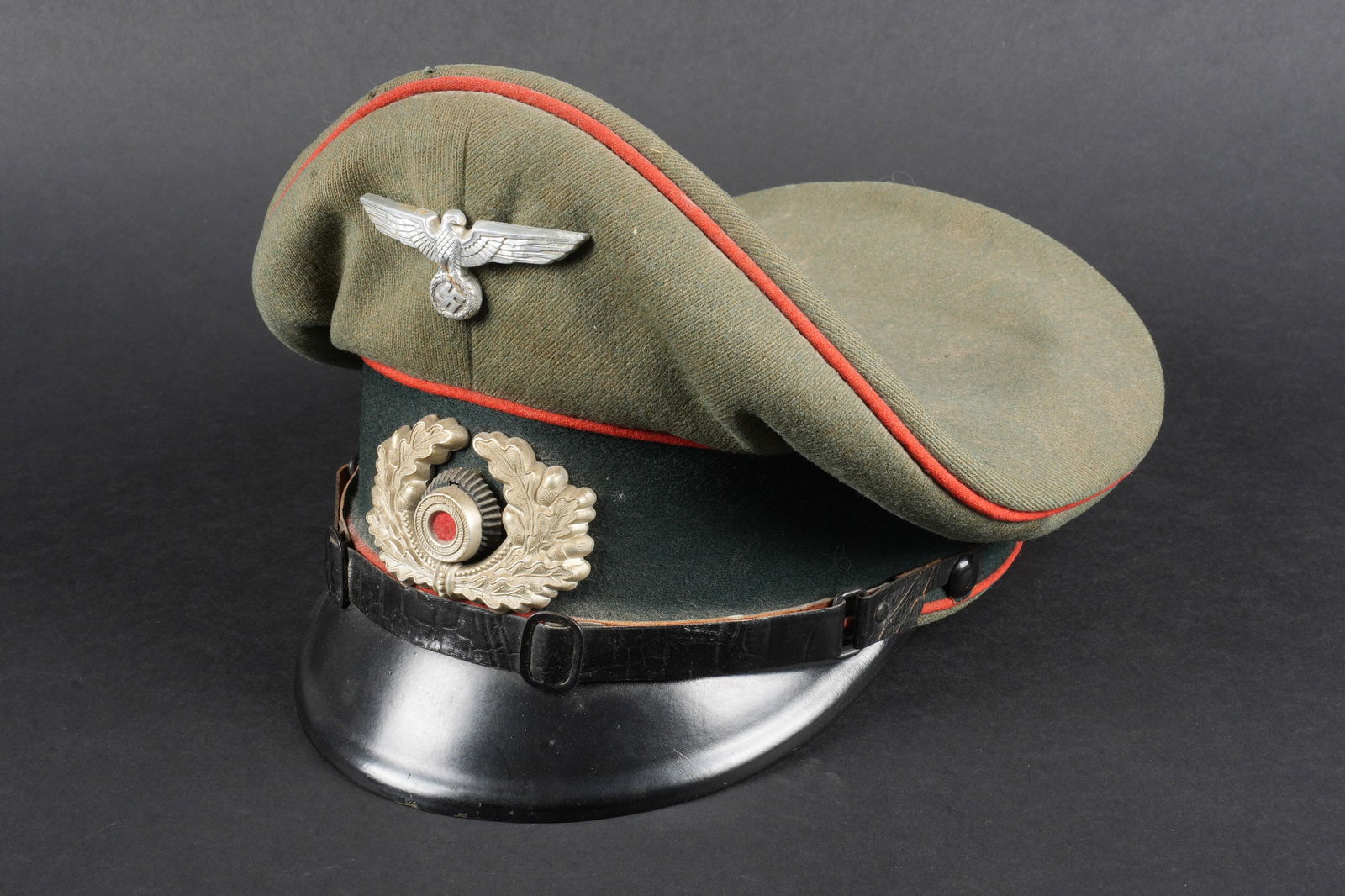 Casquette artillerie. German artillery cap.: Casquette de sous-officier de lartillerie. En gabardine Feldgrau, triple lisere rouge de lartillerie. Bandeau en drap vert fonce. Insignes metalliques. Les insignes nont pas ete demontes afin de verif